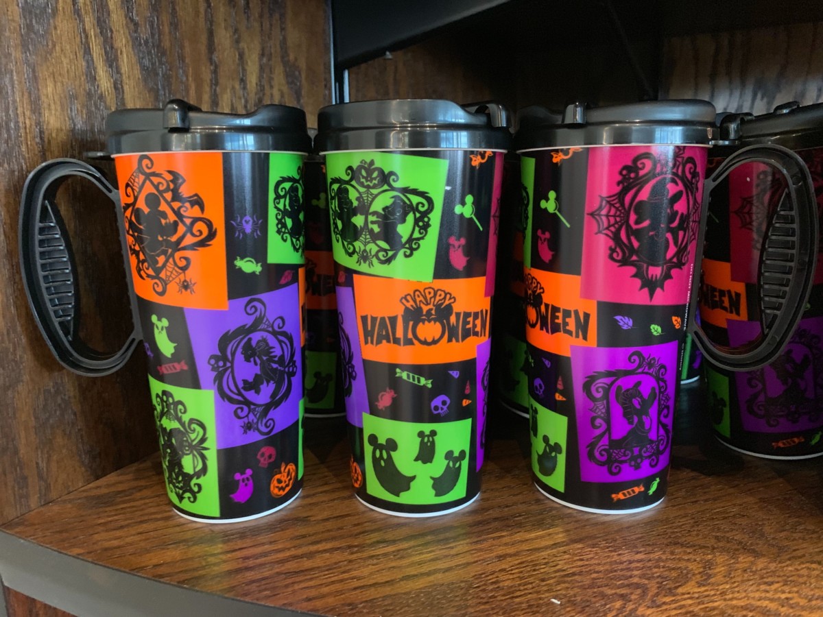 Happy Halloween versions of the Disney resort refillable mugs, with black handles and neon art of ghosts and candy.