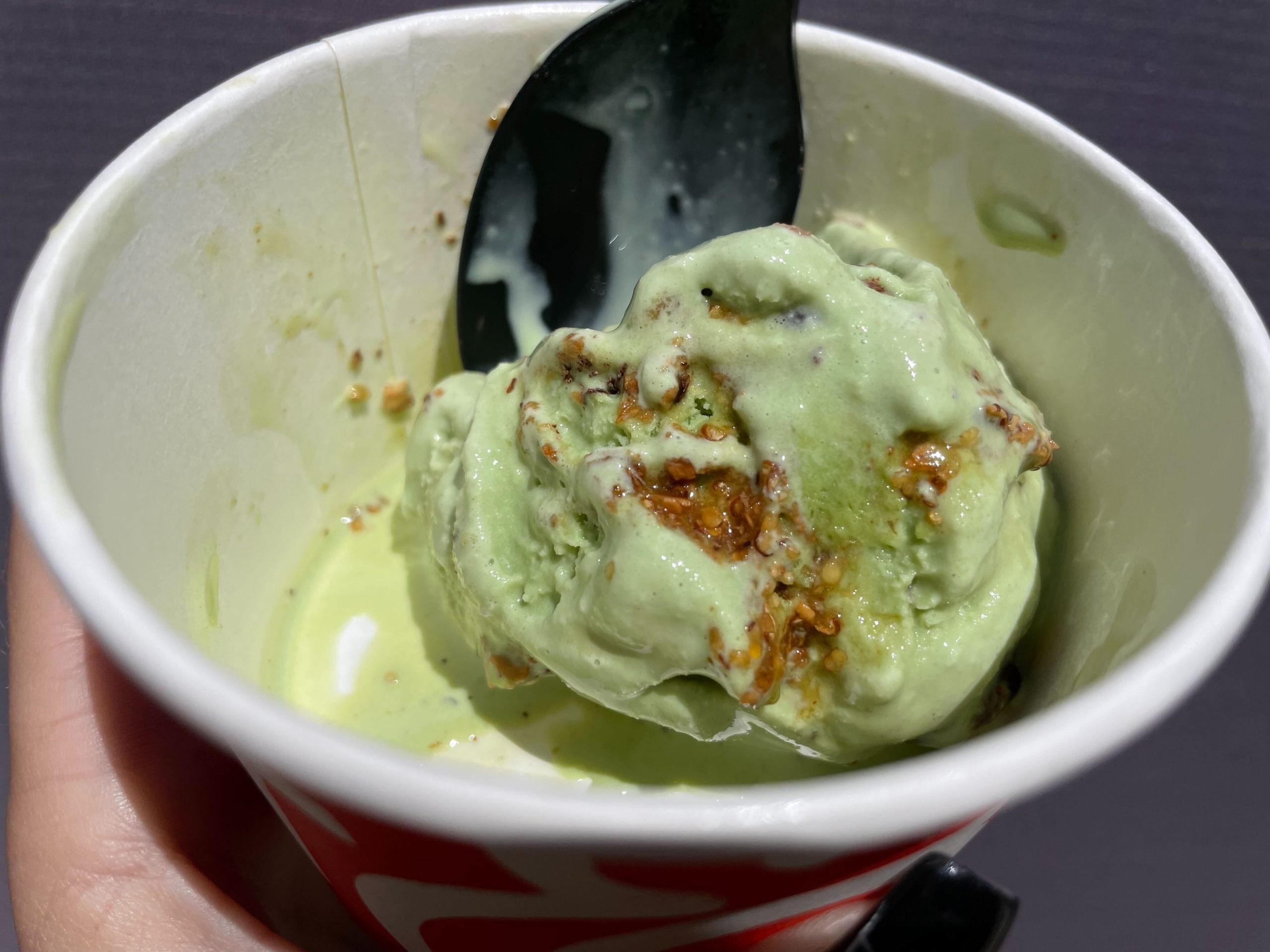 Salt & Straw ice cream cup with a scoop of Creepy Crawly Critters matcha ice cream with chocolate-covered bugs.