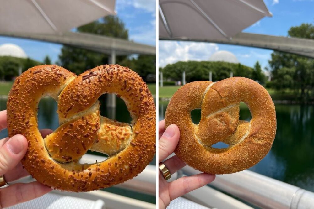 Two hands holding different types of pretzels, one with a topping and another filled with delicious stuffing, under a blue sky with water and trees in the background.