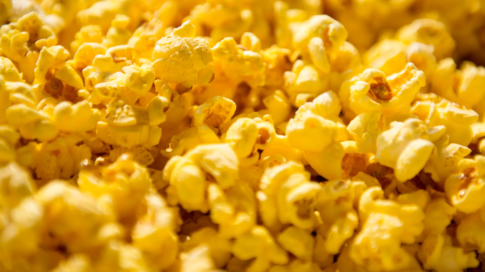 Close-up of popcorn at Central Plaza, showing bright yellow kernels and a textured, fluffy surface.