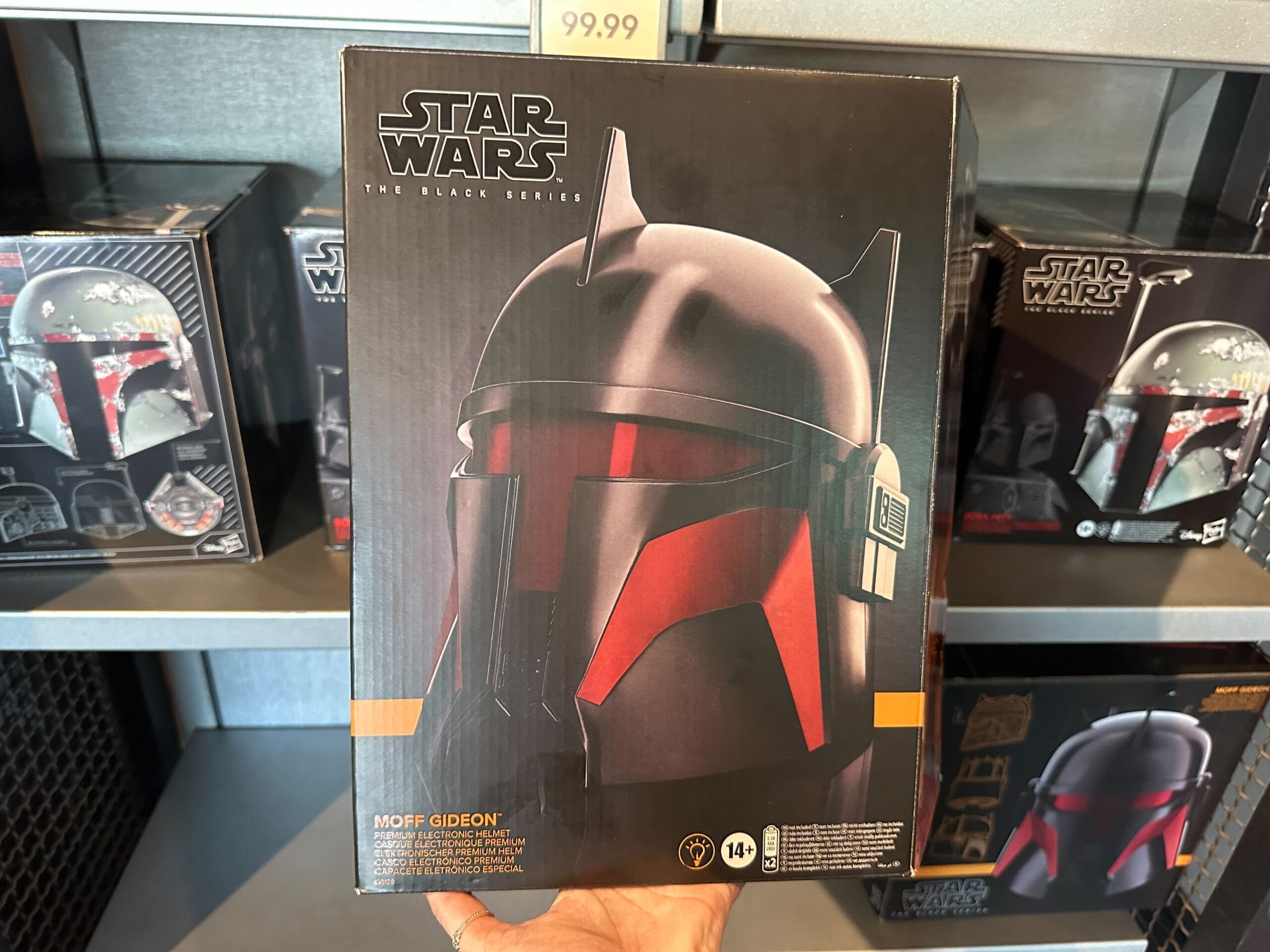 A person holds a Star Wars: The Black Series Moff Gideon helmet box in a store, priced at $99.99.