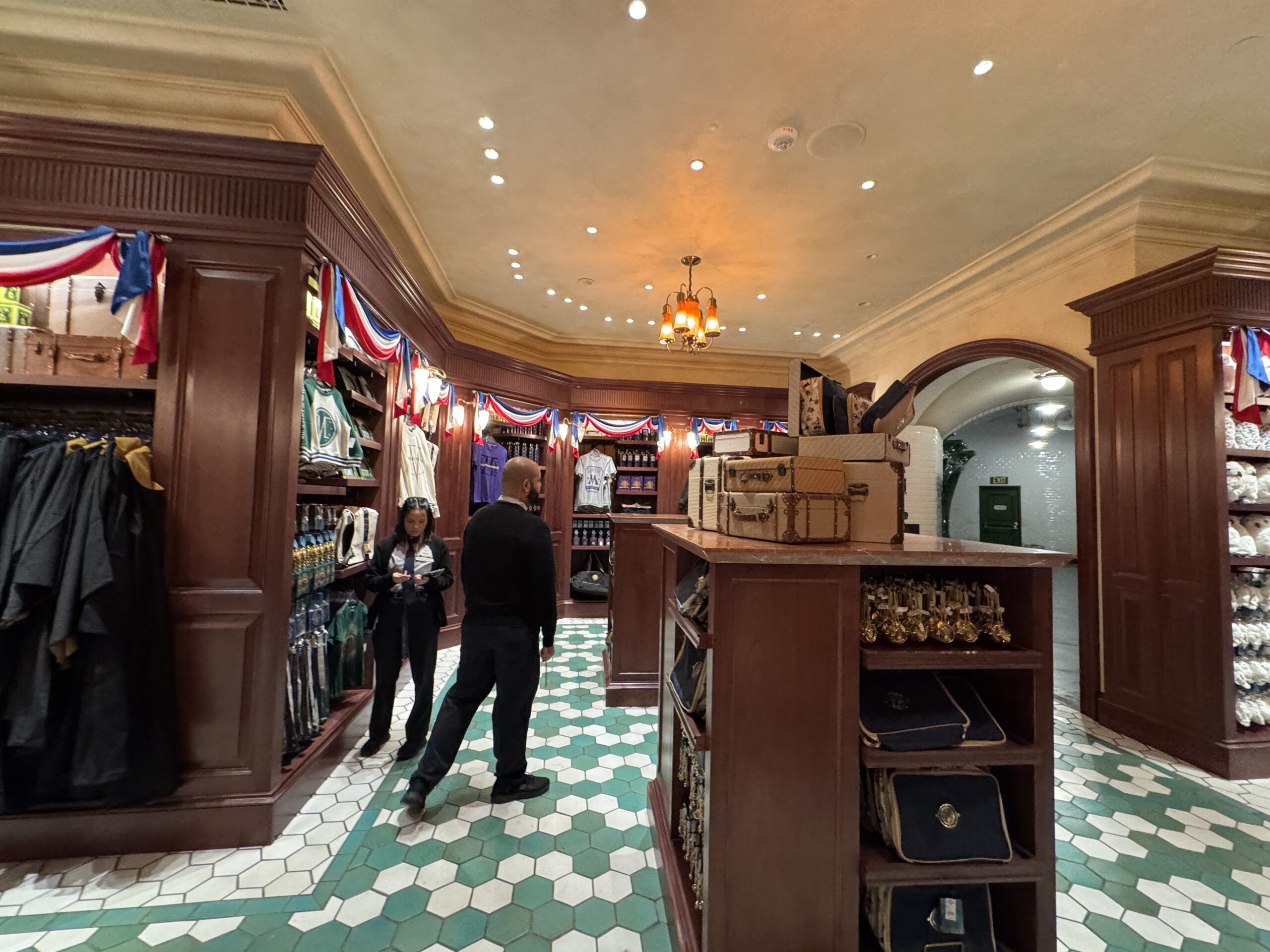 People browse Tour En Floo Shop, adorned in red, white, and blue, at the Wizarding World of Harry Potter – Epic Universe.