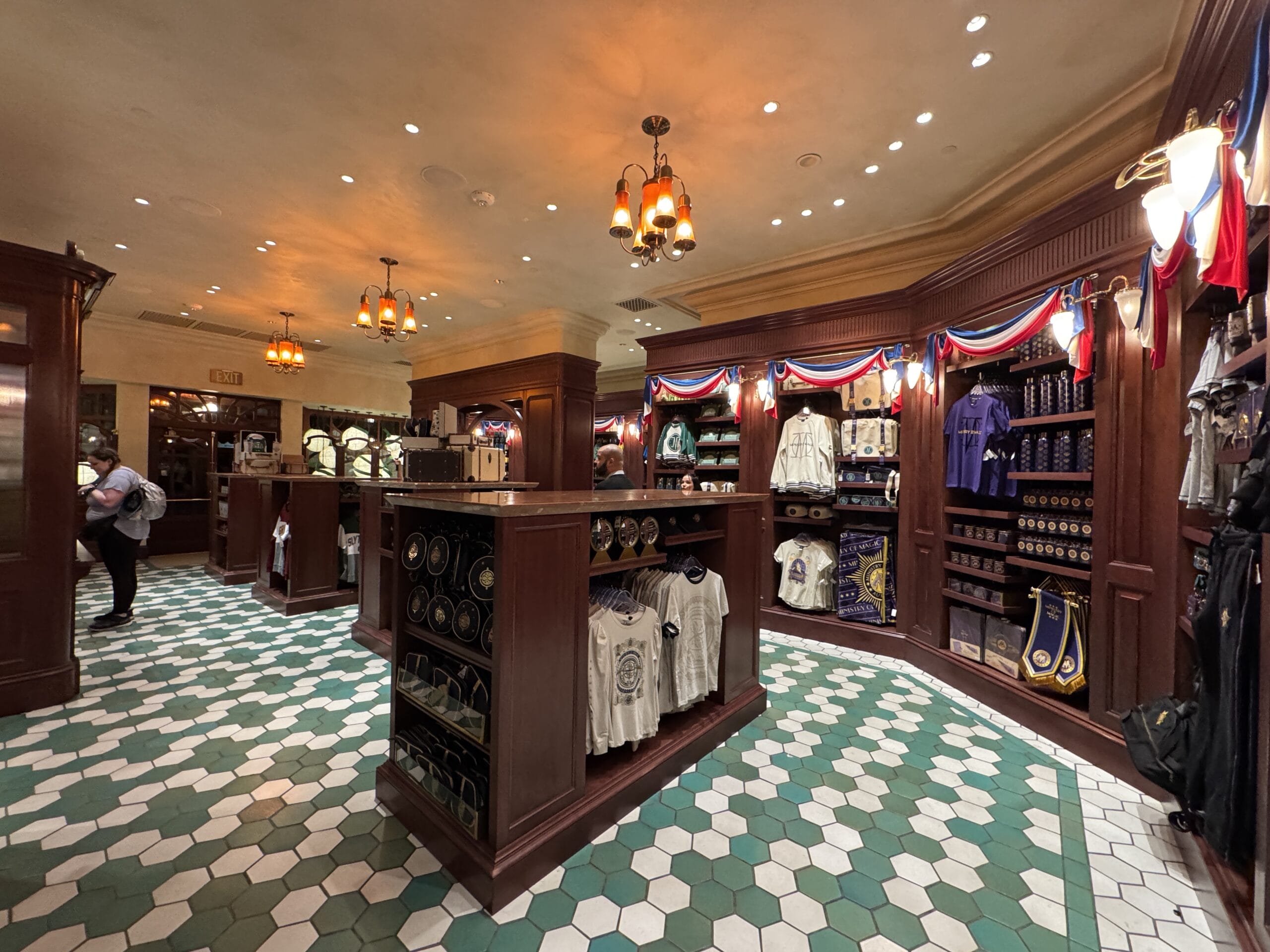 A gift shop near the Epic Universe, with wooden shelves of shirts, mugs, and bags, decorated in red, white, and blue bunting.