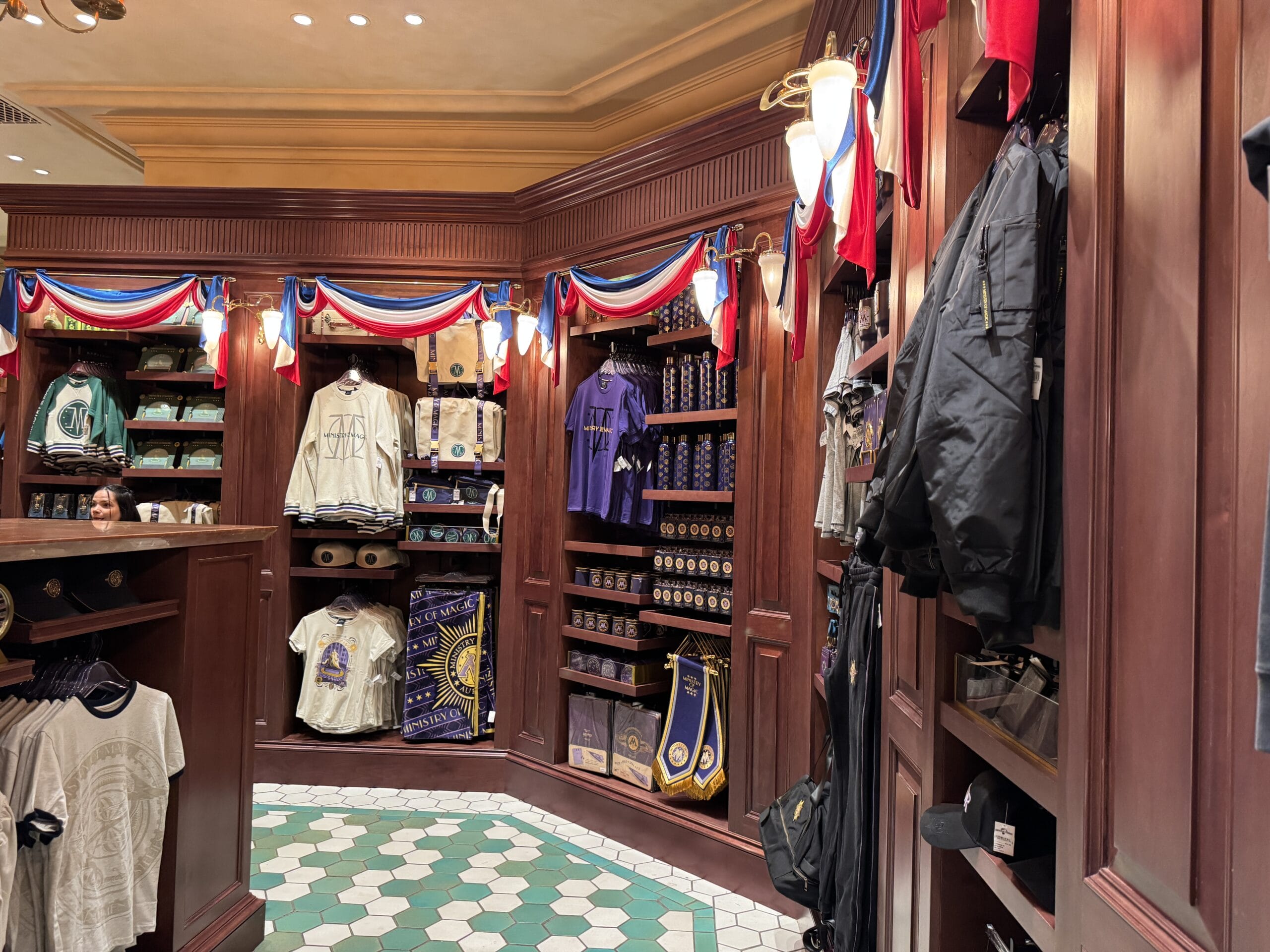 A retail store display with Wizarding World of Harry Potter shirts, jackets, and accessories beneath patriotic bunting.
