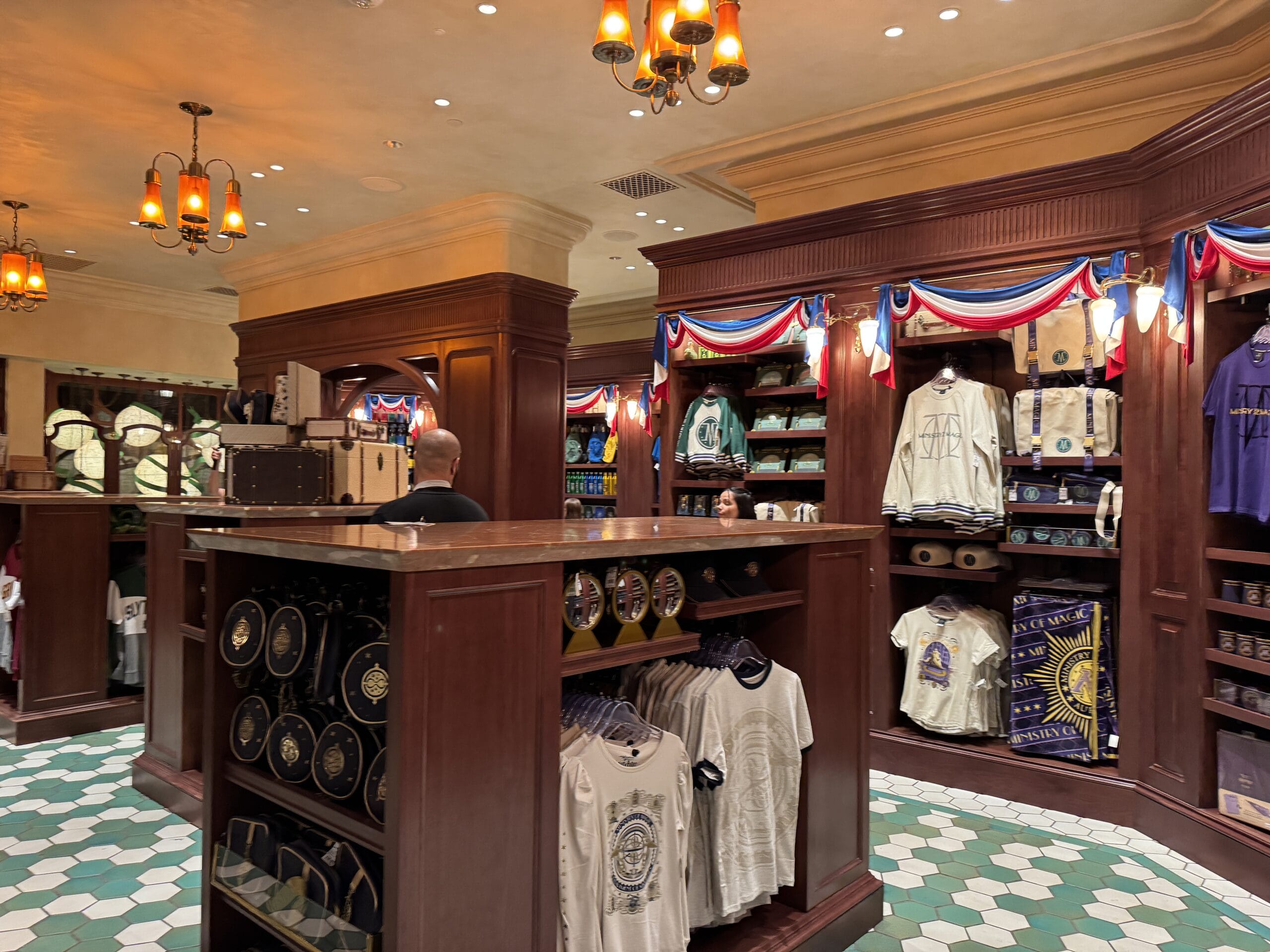Gift shop in Epic Universe with wooden shelves of Hogwarts-themed apparel, part of the Wizarding World of Harry Potter.