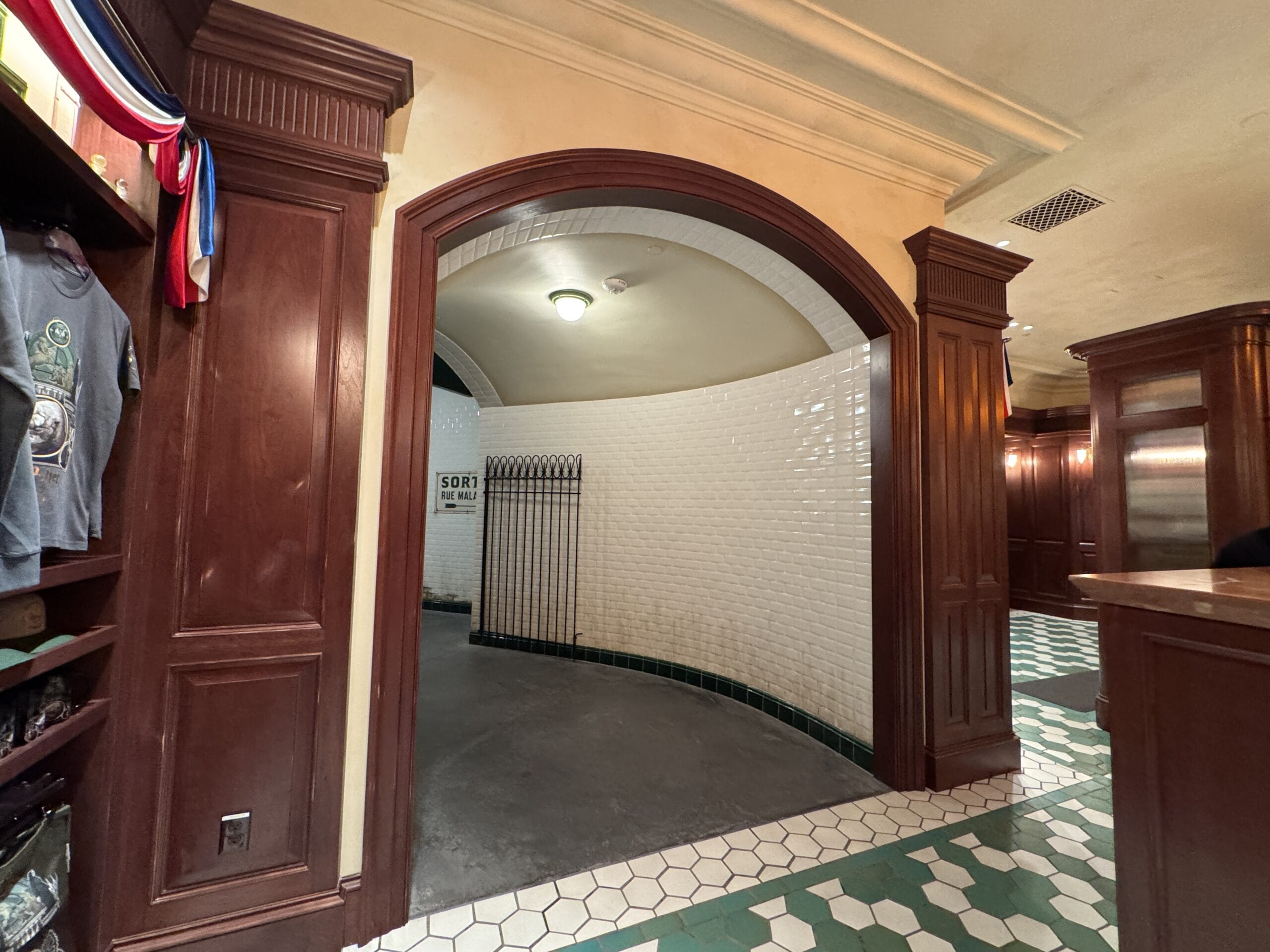 Arched hallway with white tiled walls and green trim, like the Wizarding World of Harry Potter in Epic Universe.
