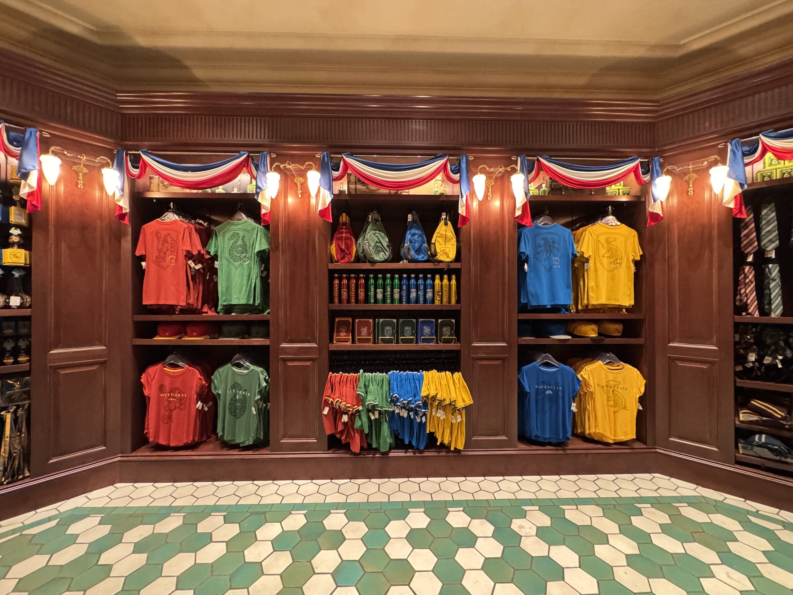 Shelves at Tour En Floo Shop display colorful shirts, adding charm to The Wizarding World of Harry Potter.