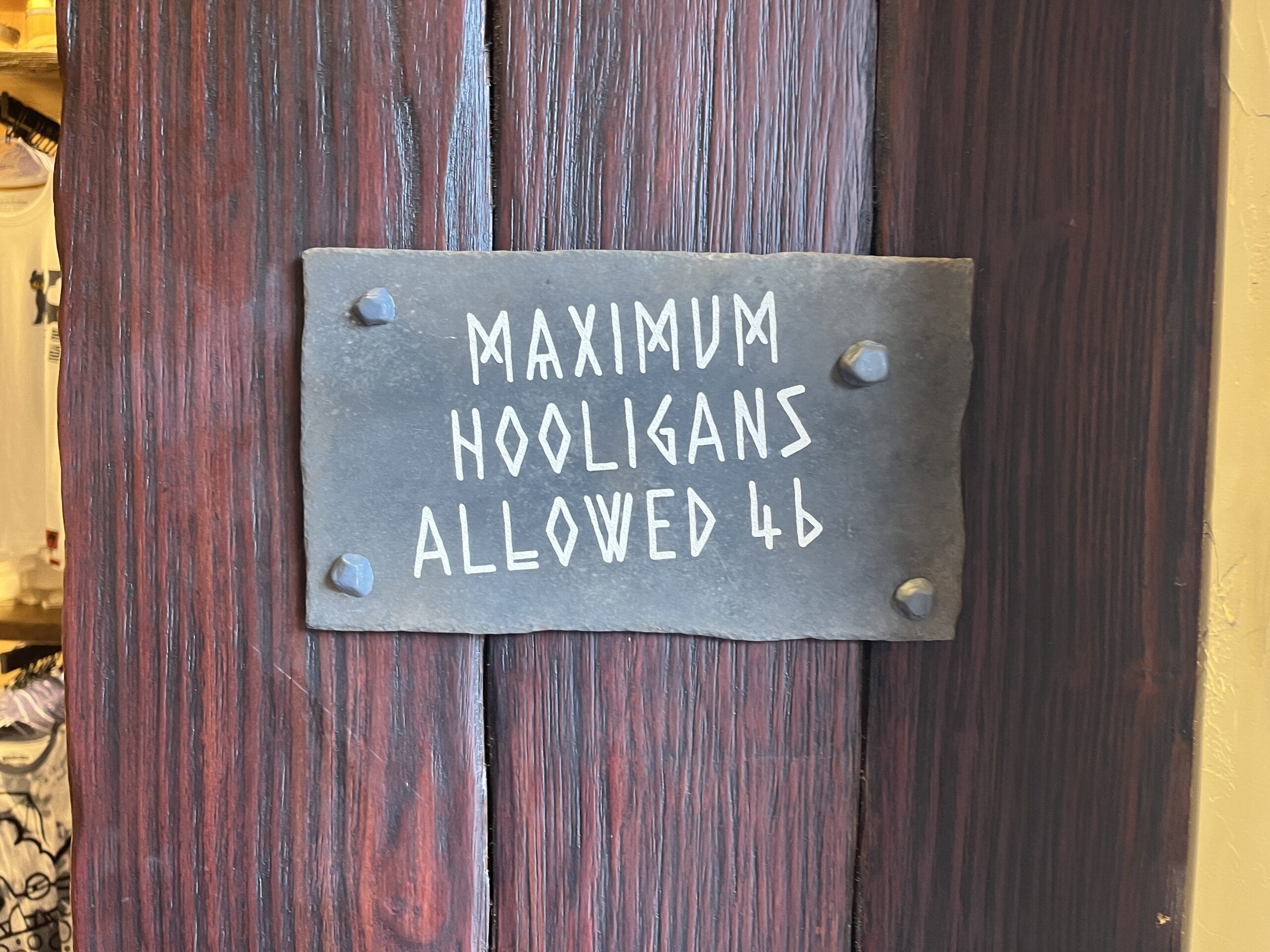 A whimsical sign on a wooden door states, "Maximum Viking Traders Allowed 46," in a traditional Berk style.
