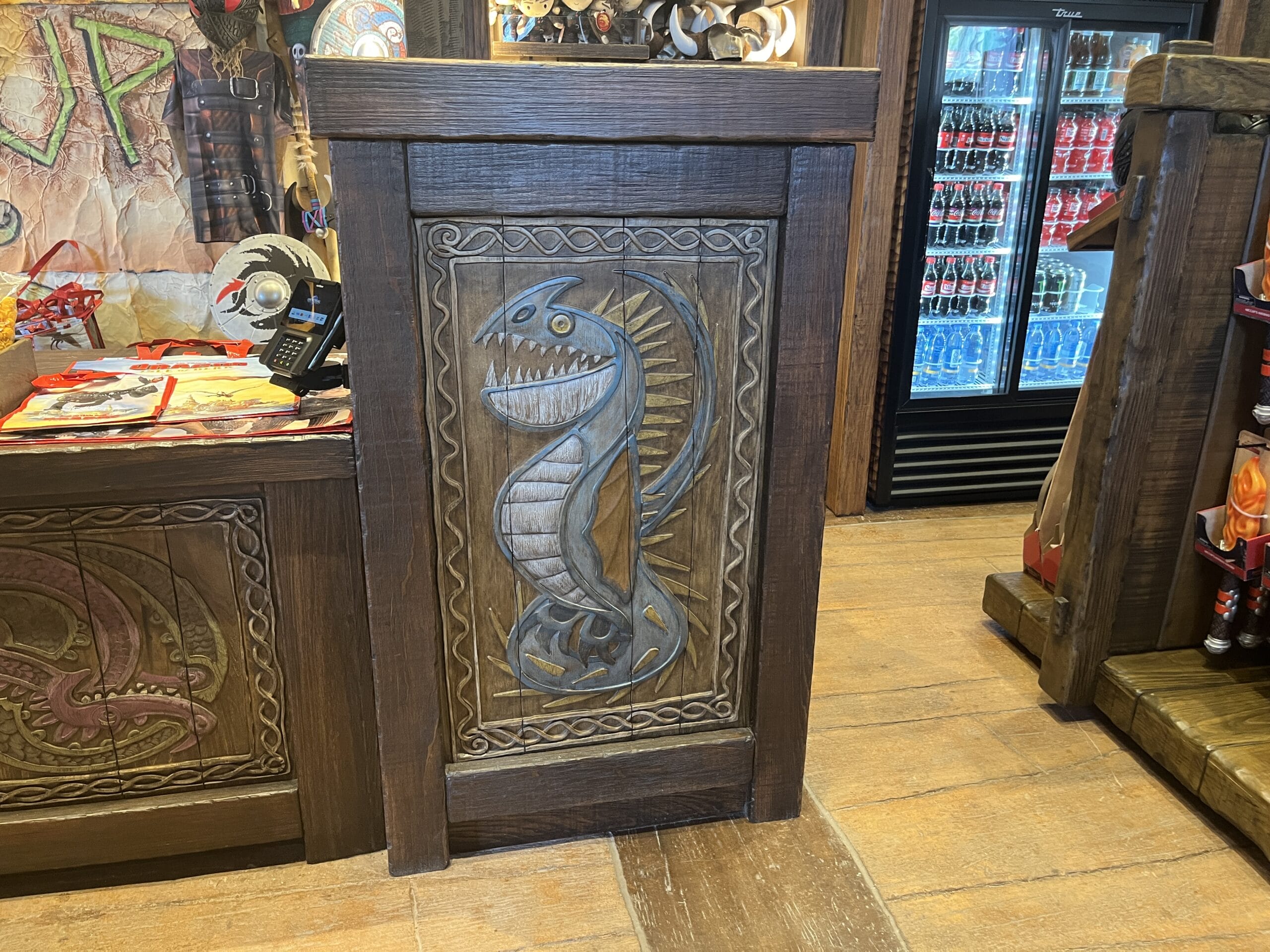 Ornately carved dragon panel at Viking Traders, refrigerator visible behind.