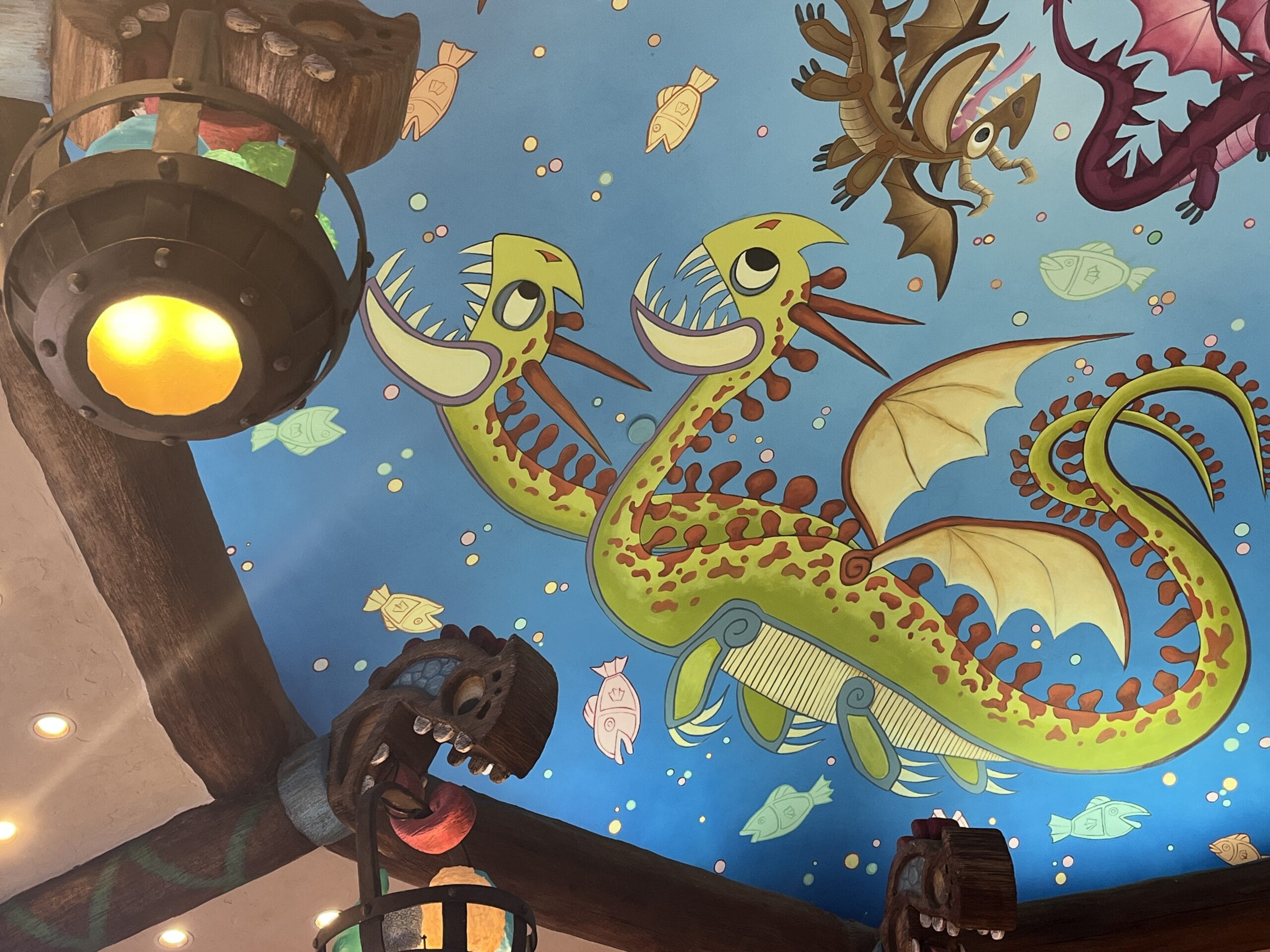 Cartoon two-headed dragon with wings decorates a blue ceiling, playfully themed for How to Treat Your Dragon fans.