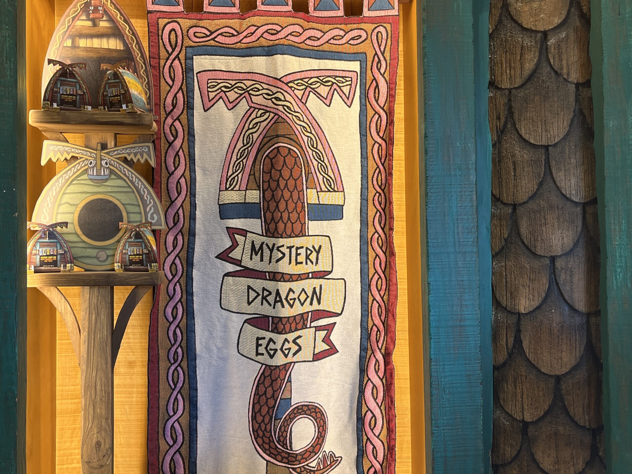 A tapestry reading "Mystery Dragon Eggs" hangs beside wooden shelves, inspired by How to Treat Your Dragon.