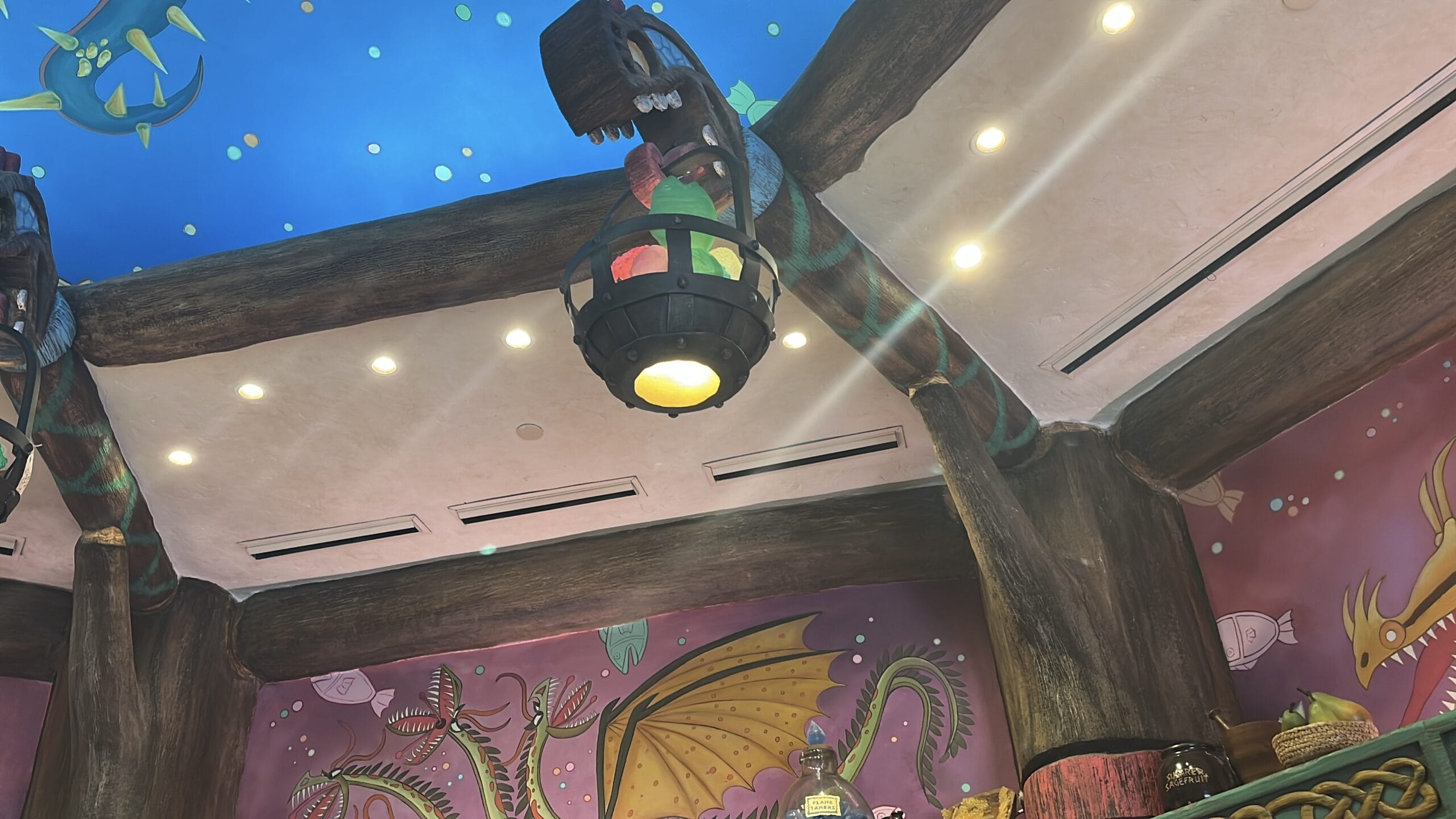 Colorful ceiling with painted dragons, blue sky, and a lantern inspired by How to Treat Your Dragon.