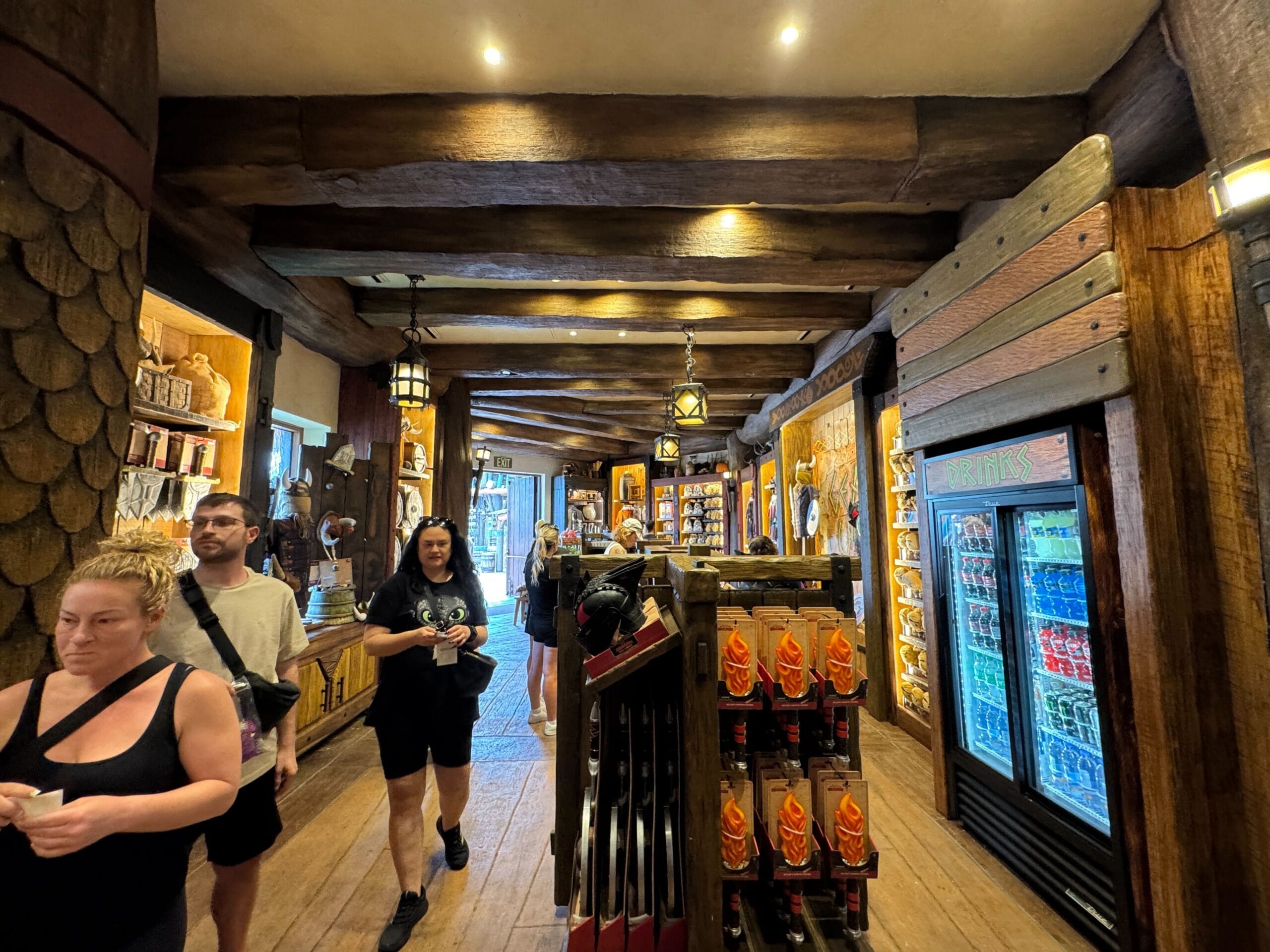 Guests browse Viking Traders, filled with wood beams, dragon snacks, drinks, and Isle of Berk souvenirs.