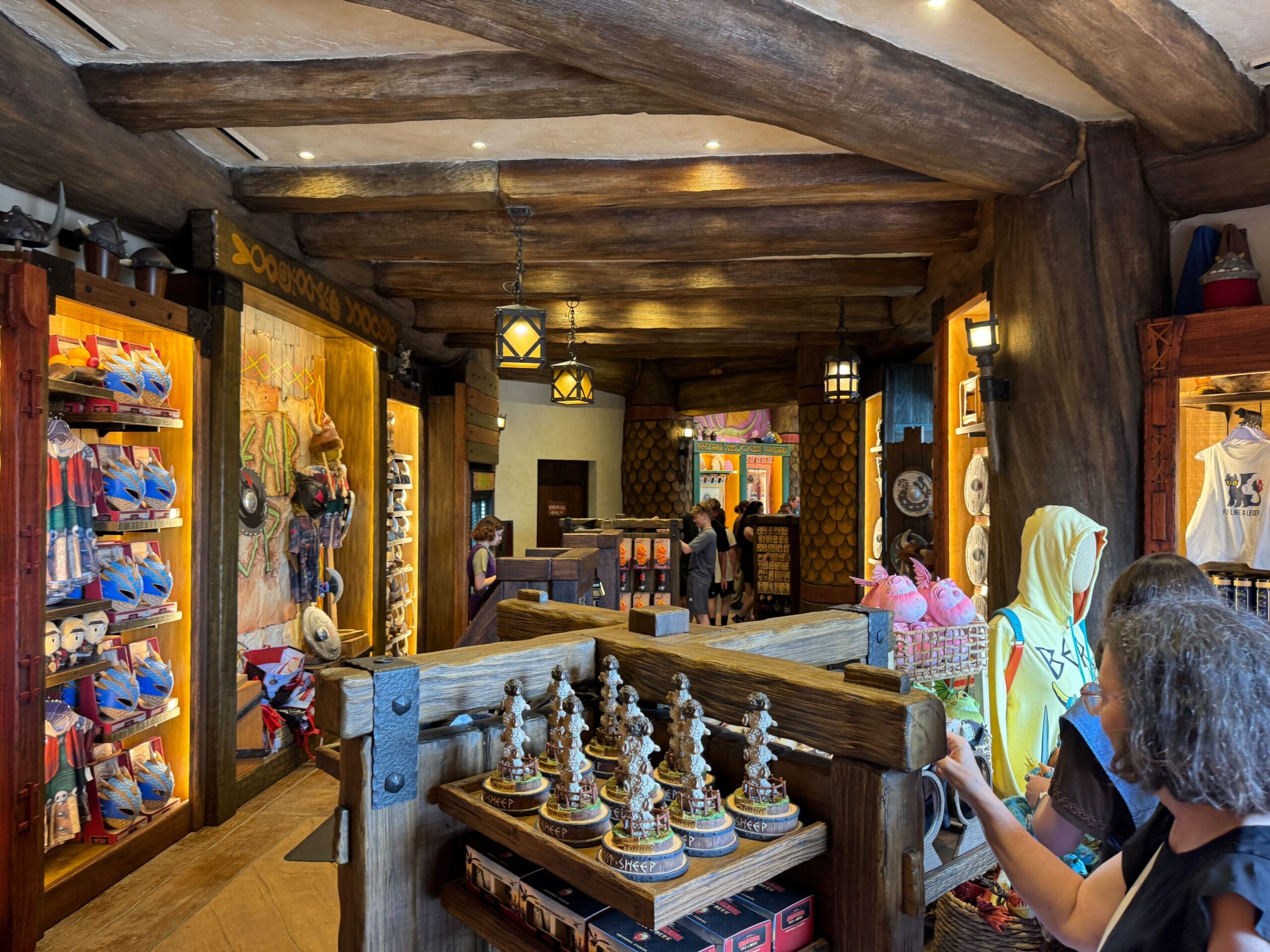 Viking Traders gift shop with wooden beams, themed souvenirs, figurines, and guests exploring colorful displays.