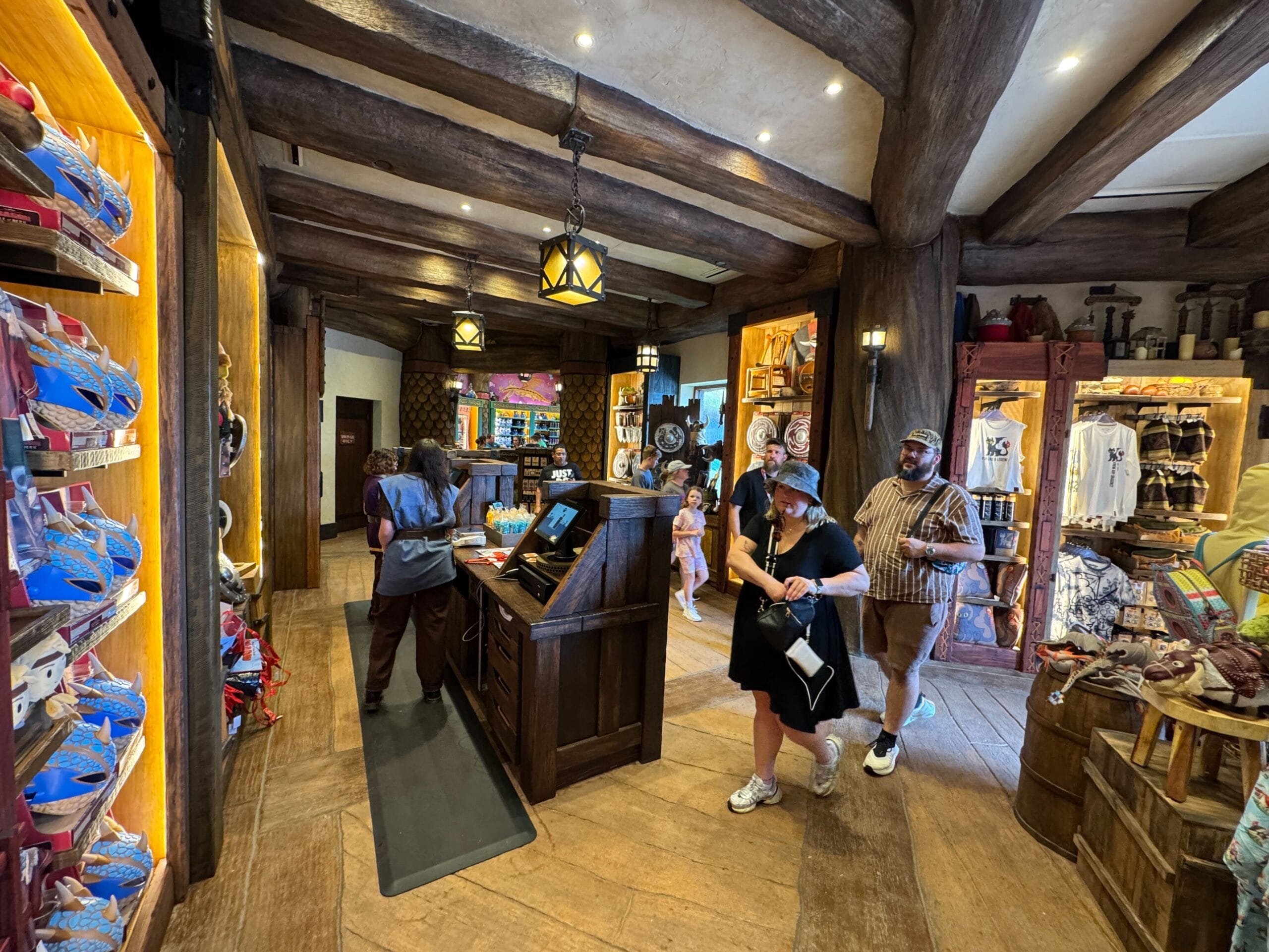 Guests explore Viking Traders, a cozy, wooden gift shop at Epic Universe, filled with apparel and plush toys.