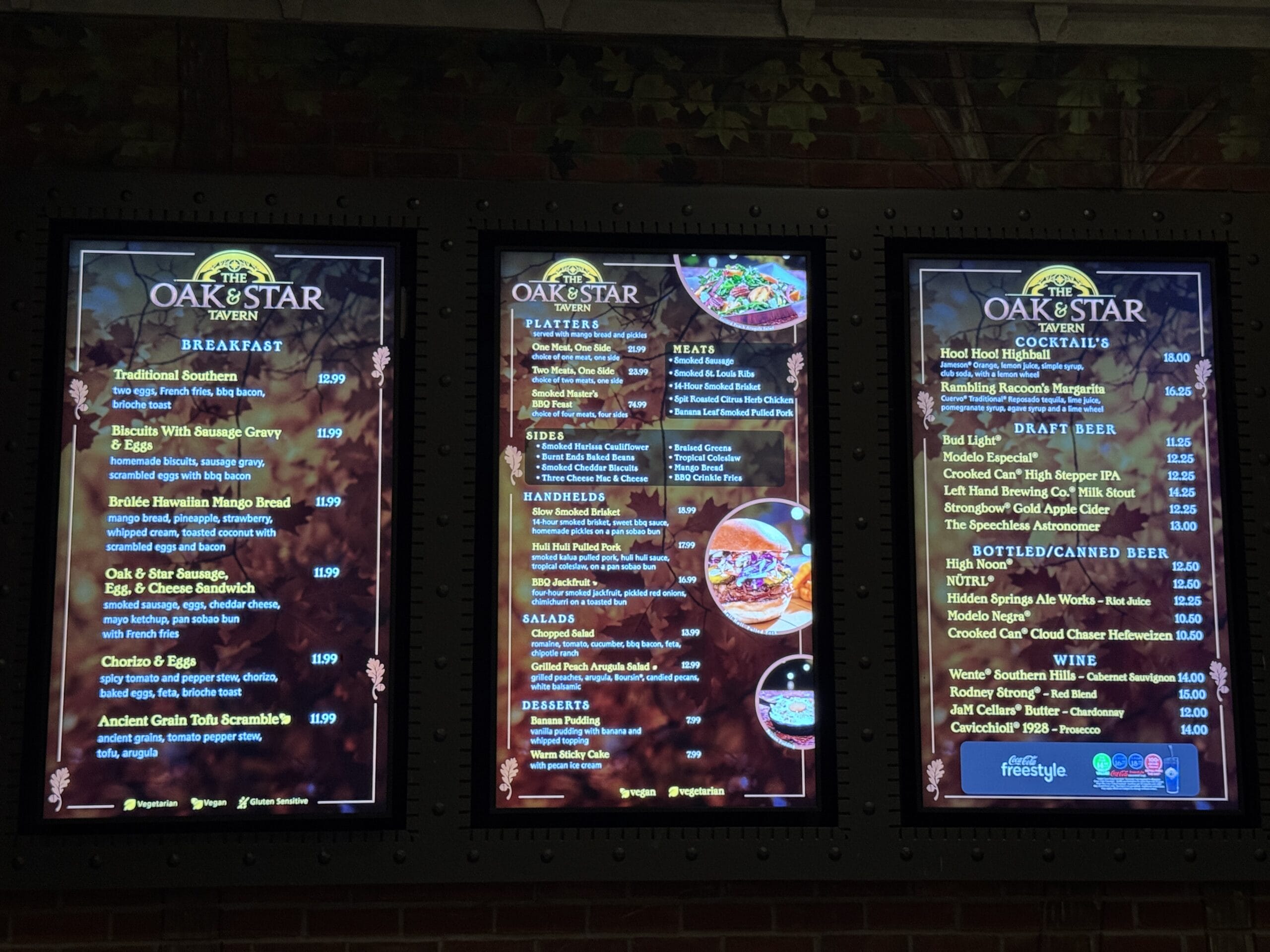 Three digital menu boards display breakfast, platters, and drinks at The Oak & Star Tavern.