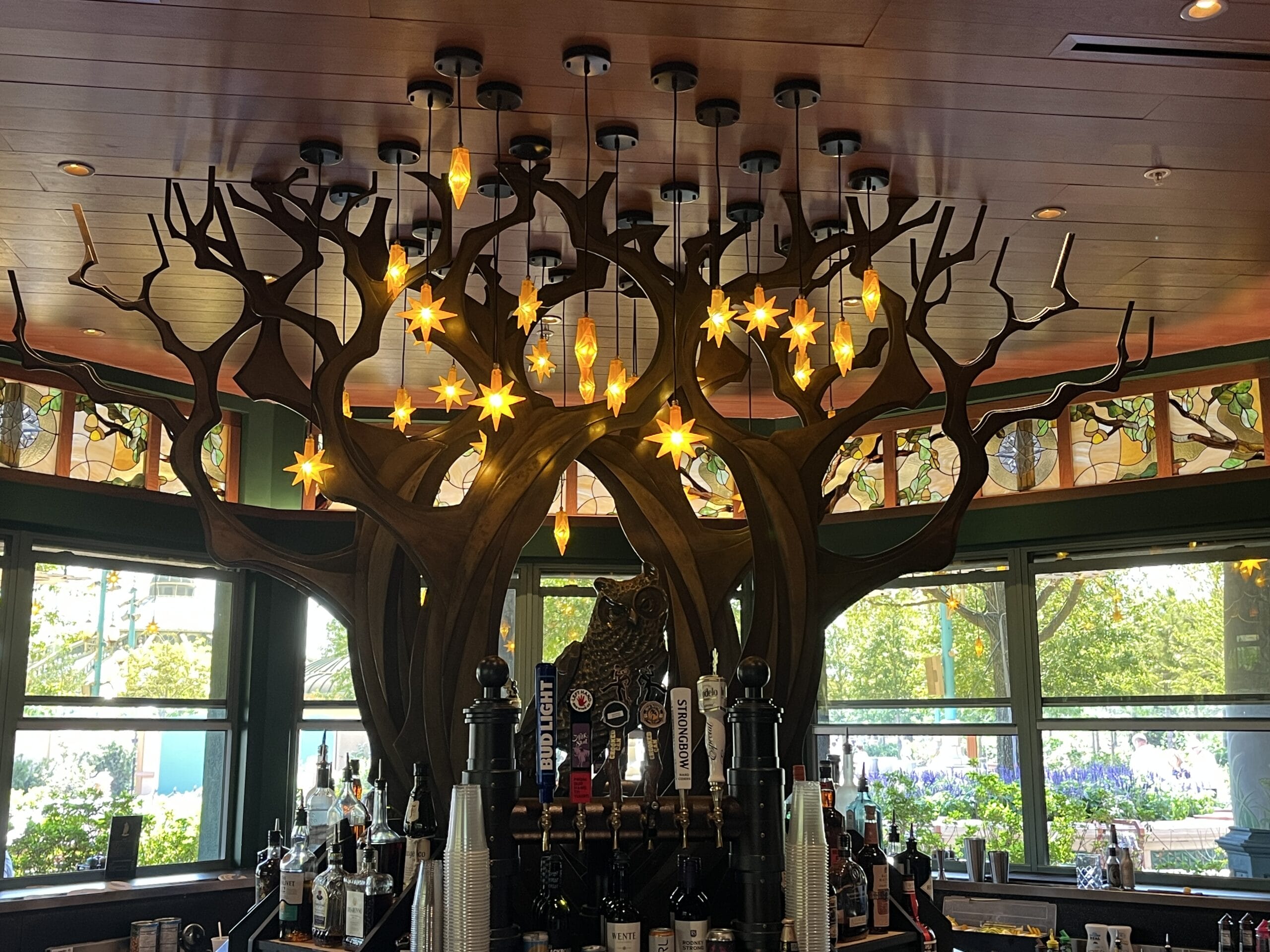 The Oak & Star Tavern’s whimsical, tree-shaped wood decor and star pendant lights evoke fantasy vibes like a Disney park restaurant.