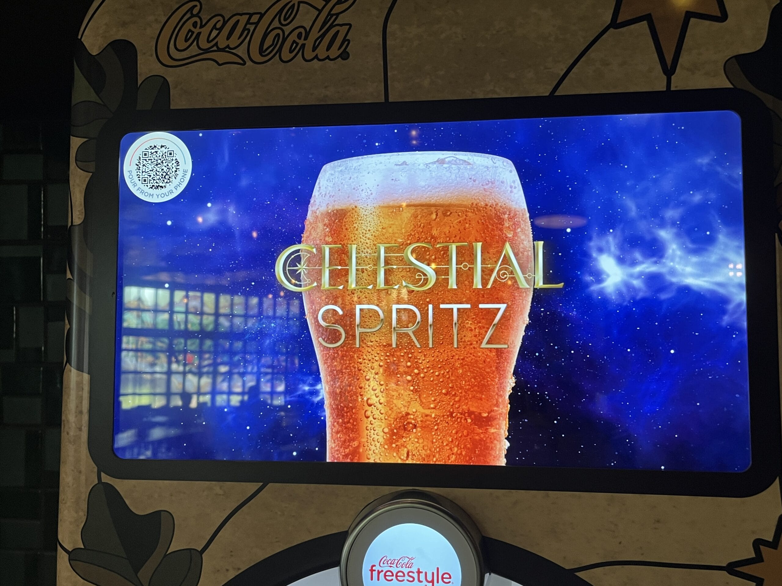 A digital menu at The Oak & Star Tavern displays a glass of orange spritz labeled “Celestial Spritz” on a cosmic background, reminiscent of Epcot’s vibrant style.