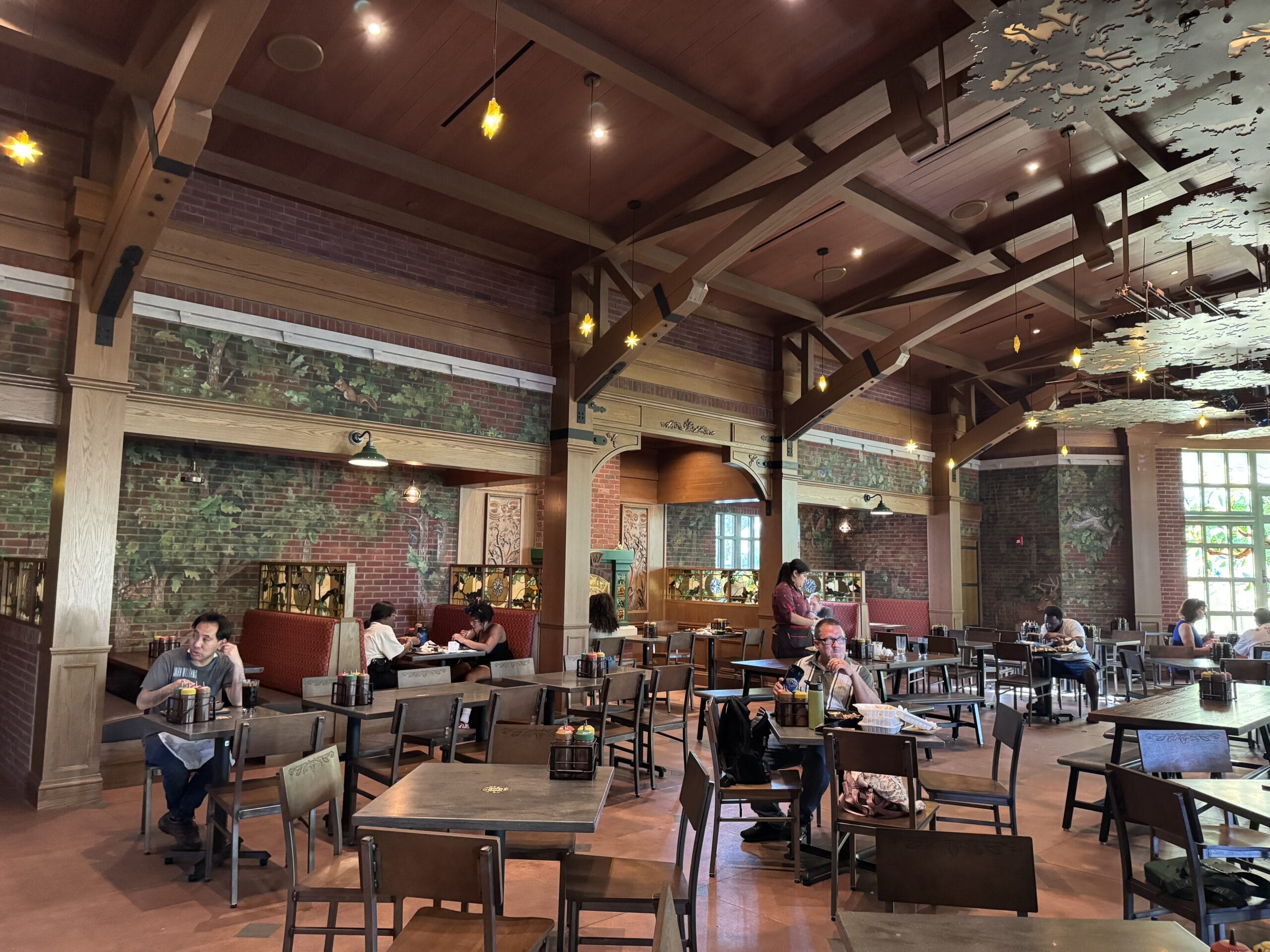 Spacious café, The Oak & Star Tavern, with wooden beams, brick walls, and big windows like those in Main Street USA at Disney parks.