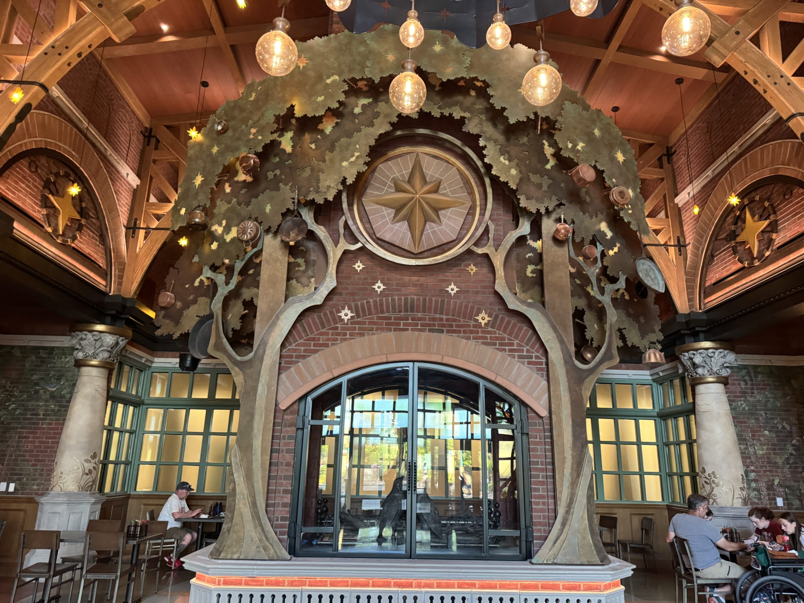 Glowing tree sculpture arching over diners at The Oak & Star Tavern, reminiscent of imaginative Disney park theming.