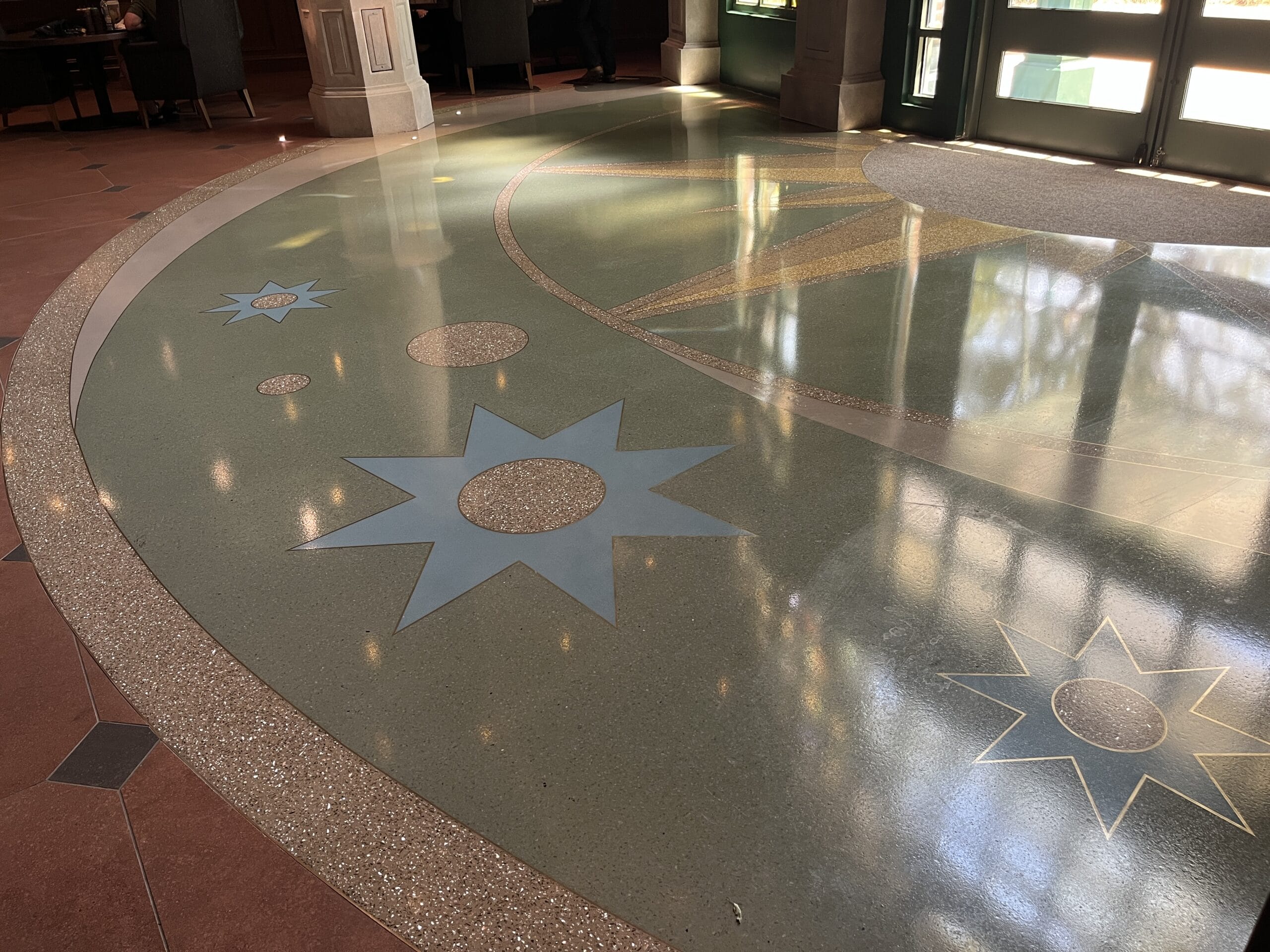 A polished floor with blue star and circle patterns welcomes guests to The Oak & Star Tavern, evoking a touch of Disney charm nearby.