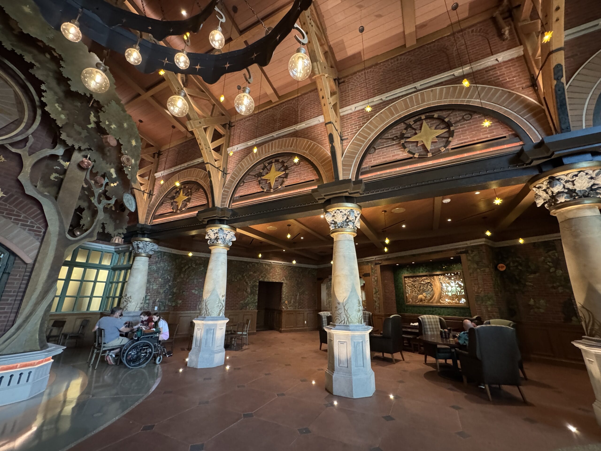 Spacious, ornate lobby at The Oak & Star Tavern with high ceilings and decorative columns, reminiscent of a Disney park hotel.
