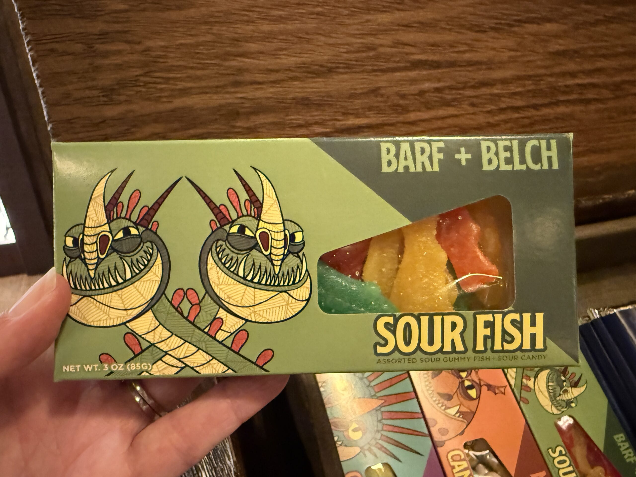 Green box labeled "BARF + BELCH SOUR FISH" from Viking Traders, with cartoon dragons and gummy fish in a window.