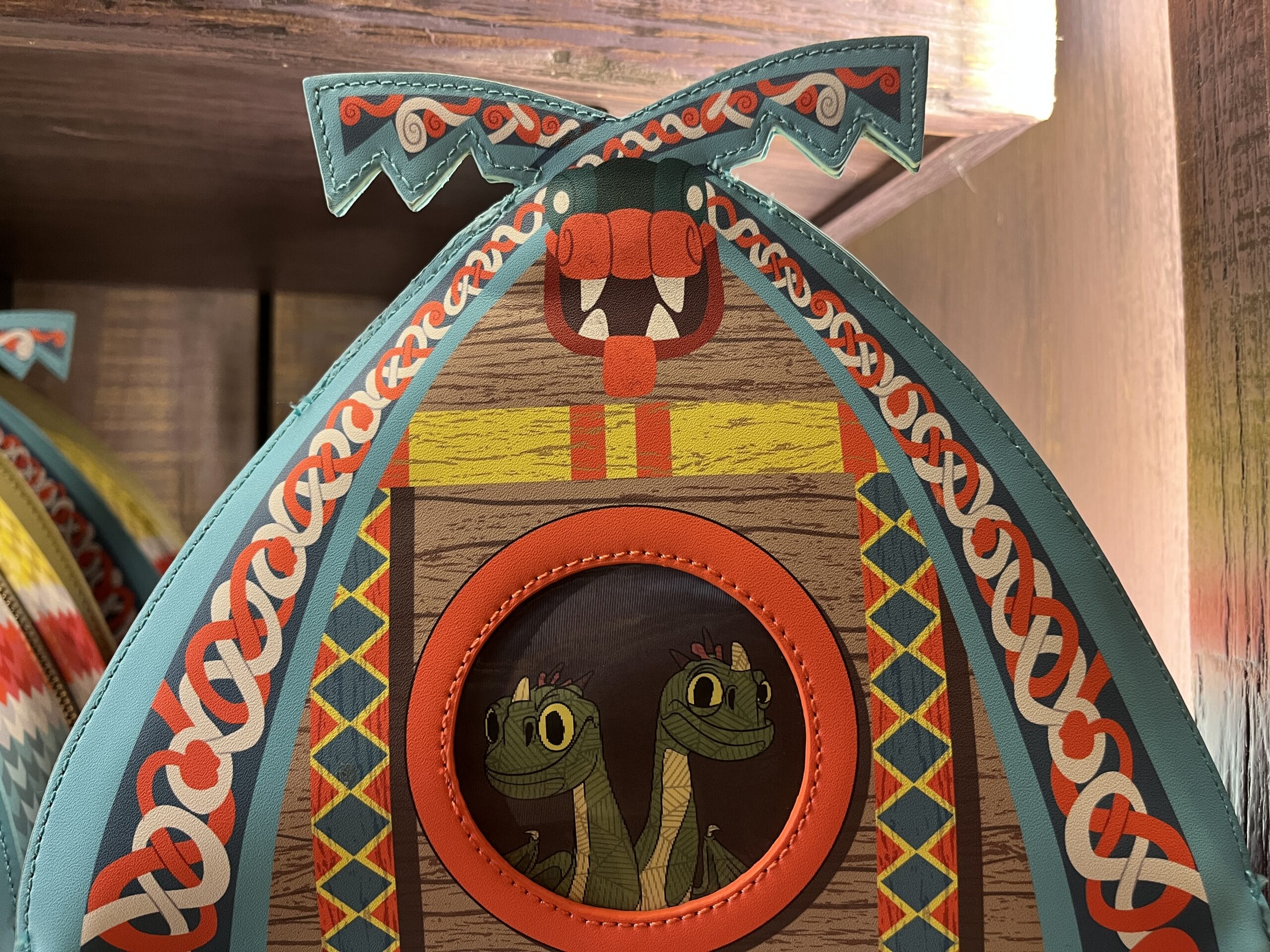 Decorative bag from Hiccup's Work Shop with a double-headed green snake and Norse-inspired patterns.