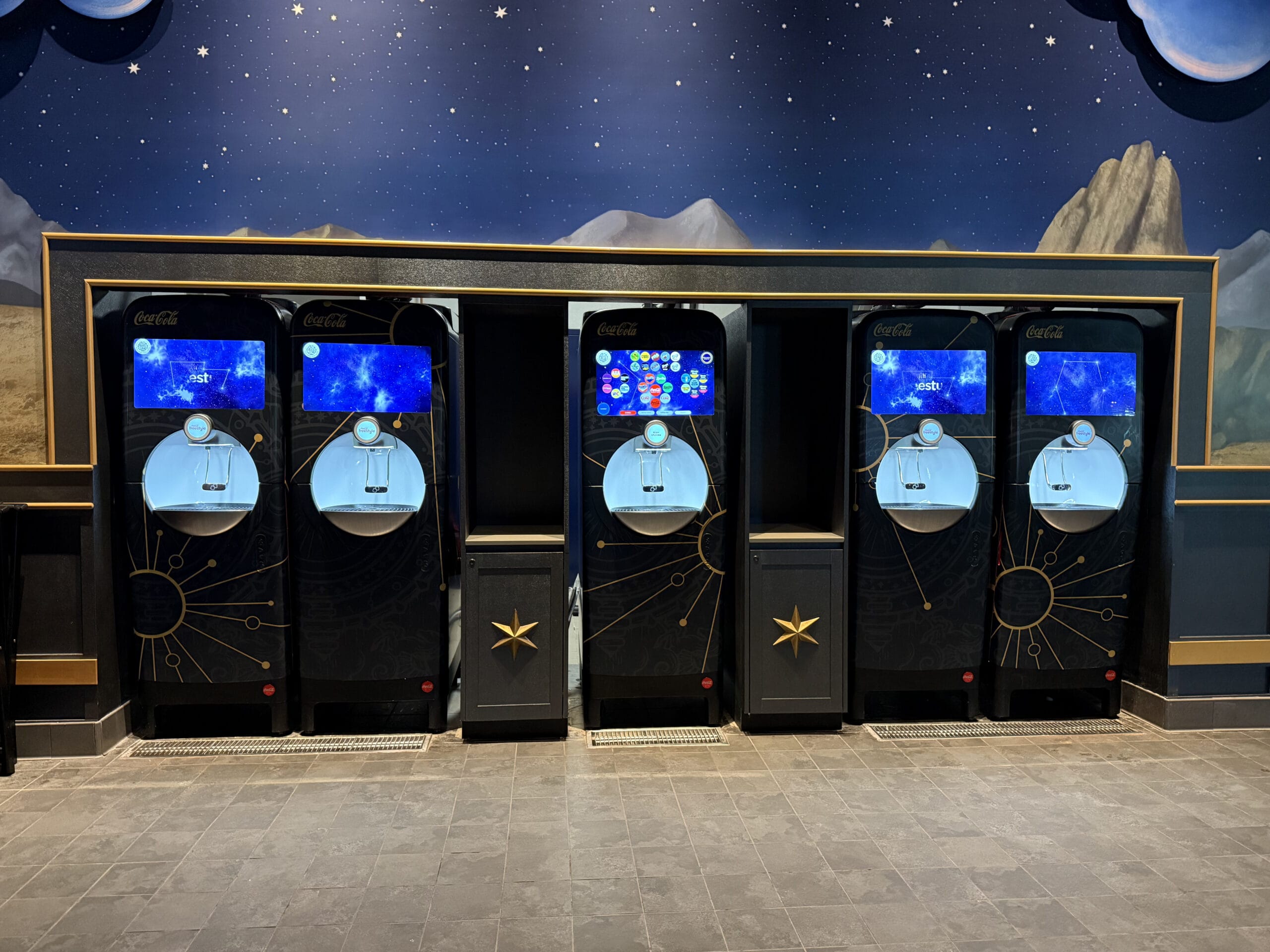 Four futuristic Coca-Cola freestyle machines at Pizza Moon Restaurant in Celestial Park, Epic Universe.