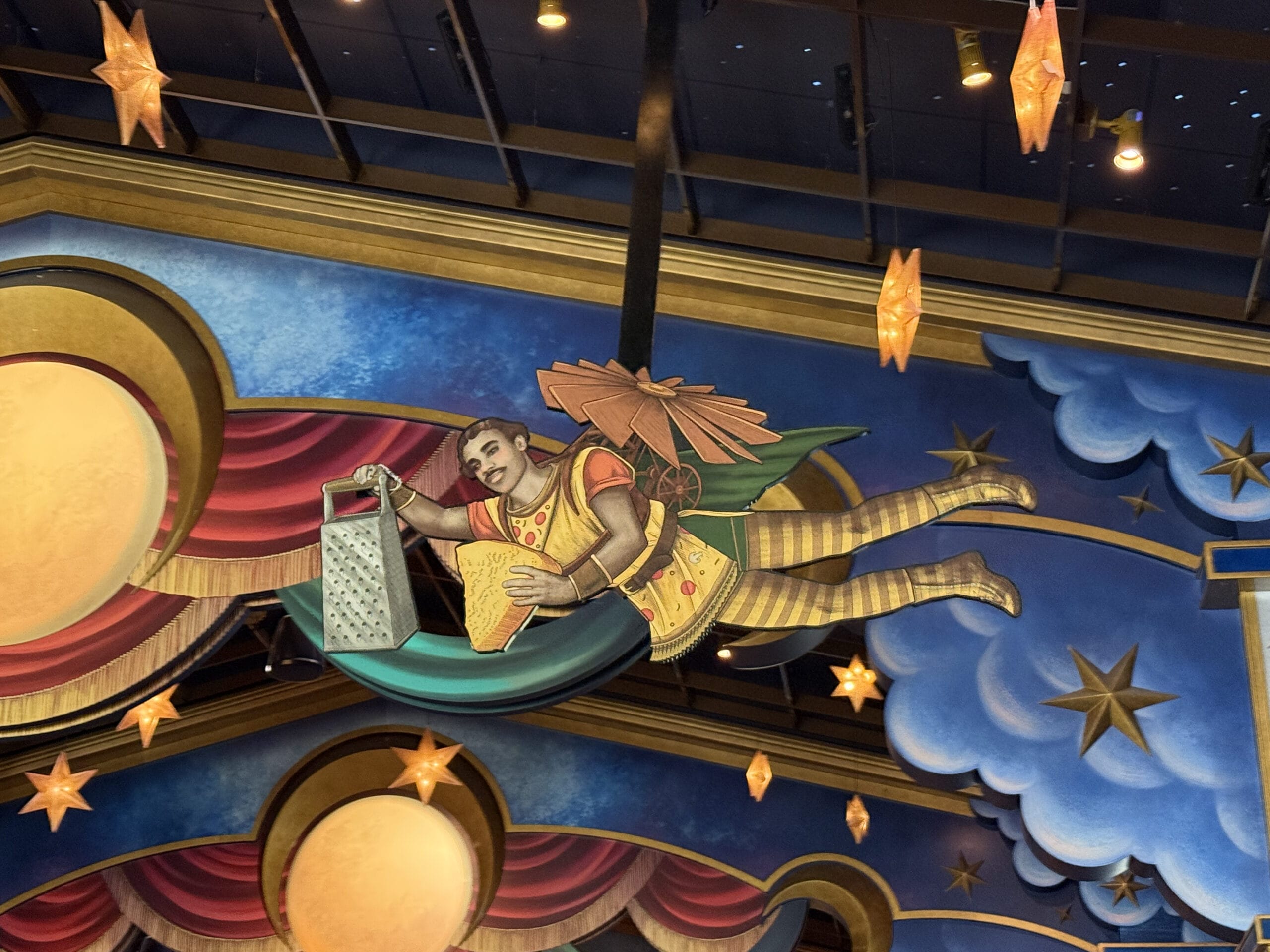A whimsical angel flies over Pizza Moon Restaurant, holding a cheese grater in a colorful, starry Epic Universe scene.