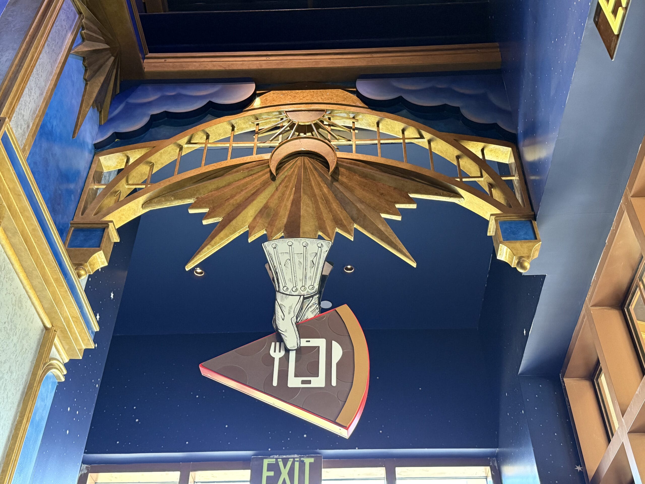 A decorative sculpture at Pizza Moon Restaurant depicts a gloved hand with a pizza slice above the Celestial Park exit.