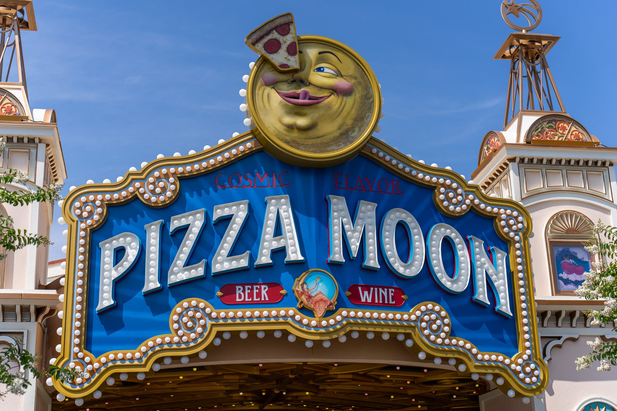 A colorful marquee reads "Pizza Moon Restaurant" in Celestial Park, with a smiling moon eating pizza above; "Beer" and "Wine" listed.