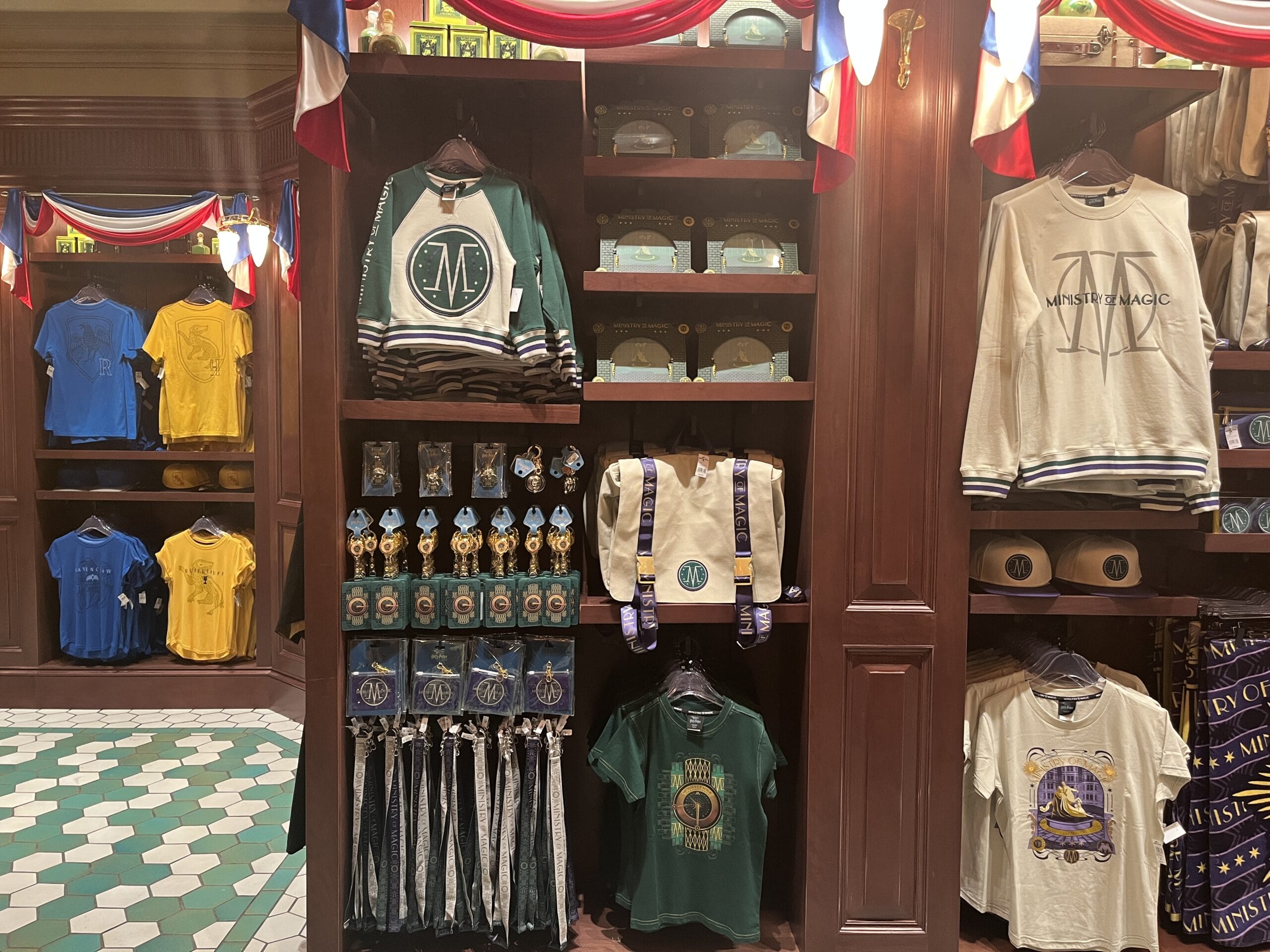 Display of themed clothing, bags, and Wizarding World of Harry Potter merchandise beneath red, white, and blue bunting.
