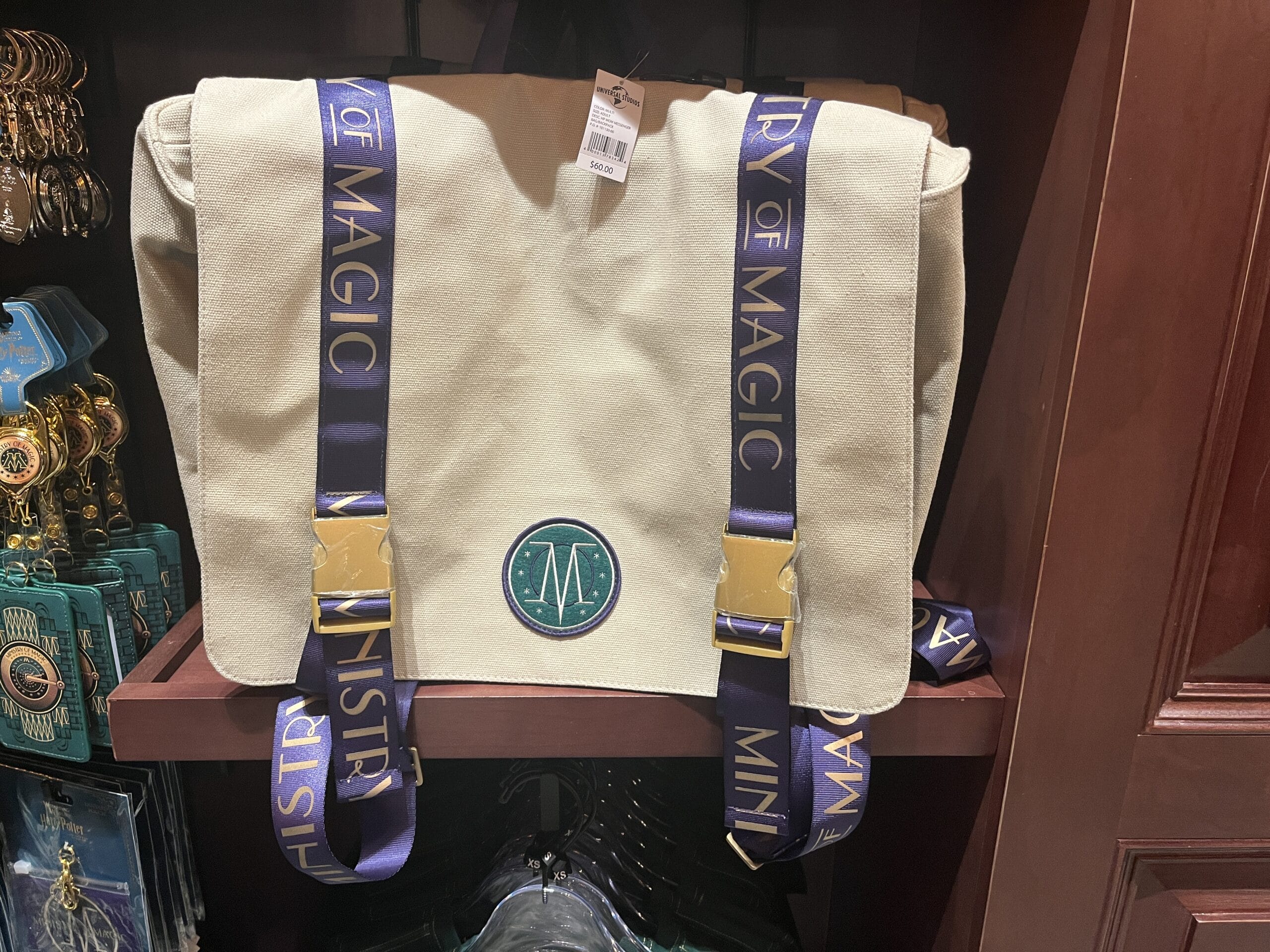 Beige messenger bag with blue "Ministry of Magic" straps—magical Wizarding World of Harry Potter merchandise on display.