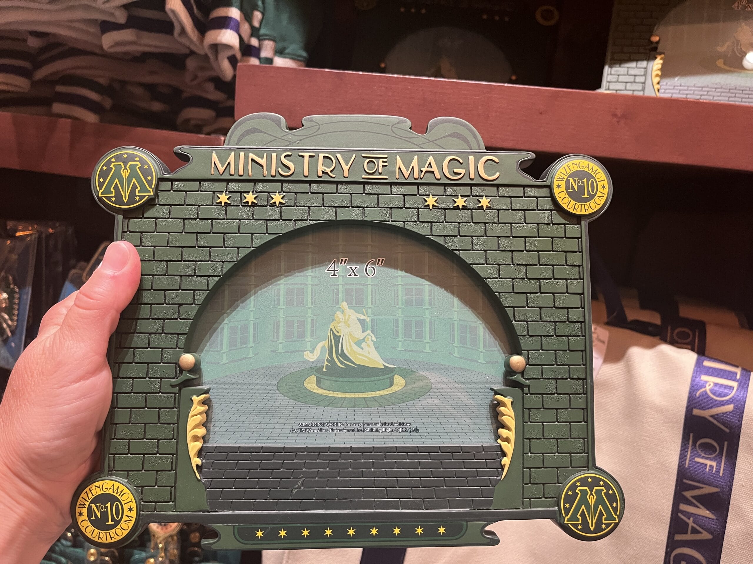 A hand holds a Ministry of Magic-themed 4x6 photo frame, perfect for Wizarding World merchandise collectors.