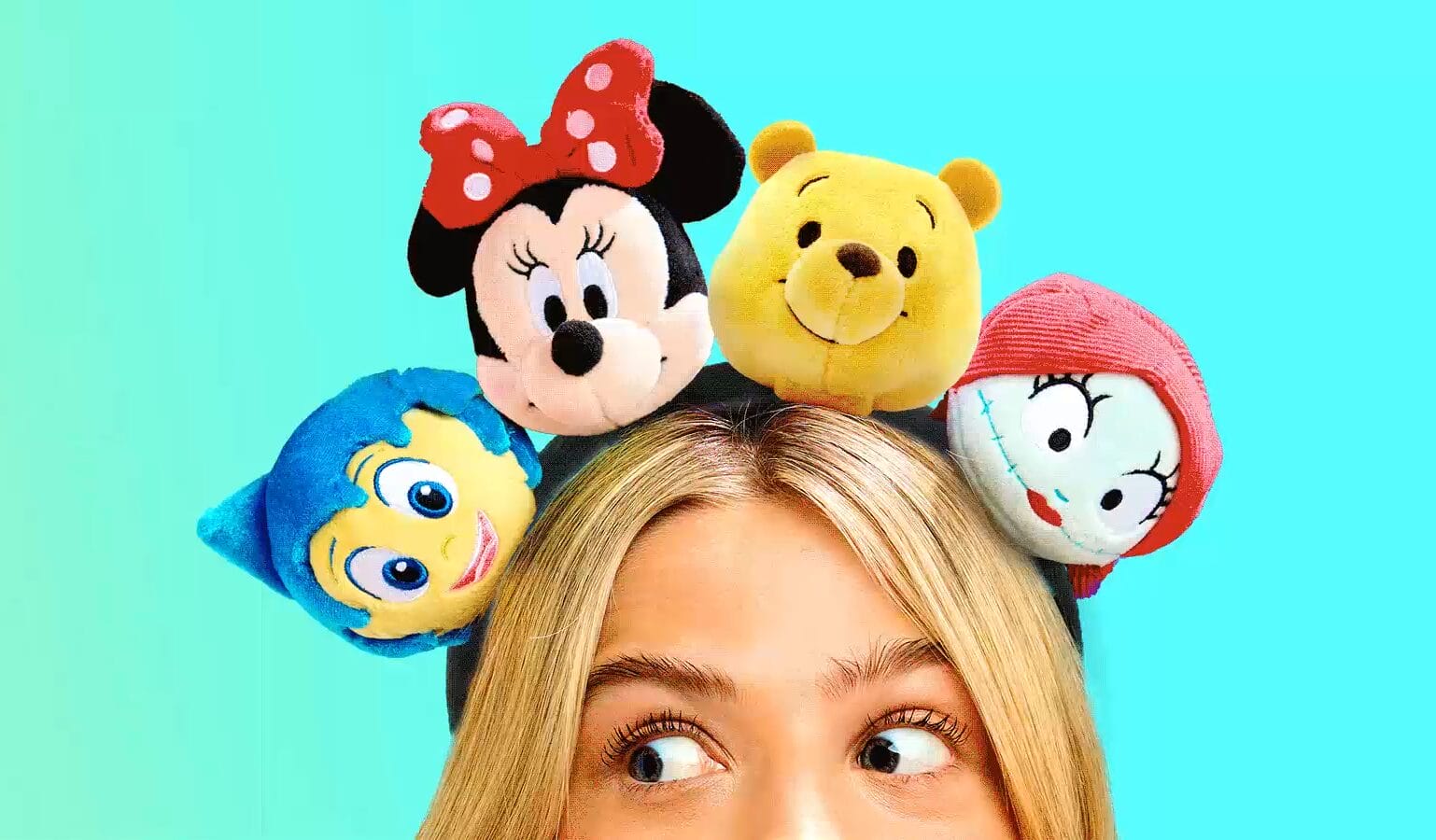 A person wears a Disney Headband Plush with character faces on a bright blue background. Shop online to create your own!