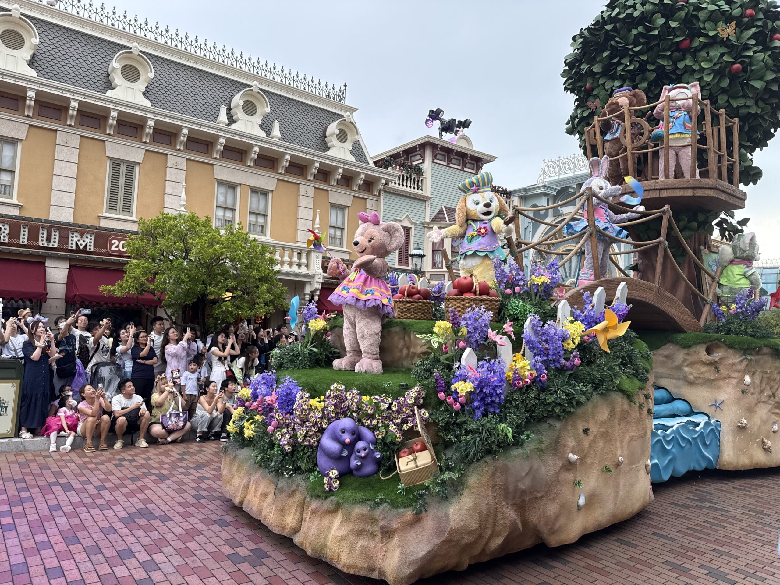 Colorful friendtastic parade float with cute animal characters and flowers delights crowds at Hong Kong Disneyland.