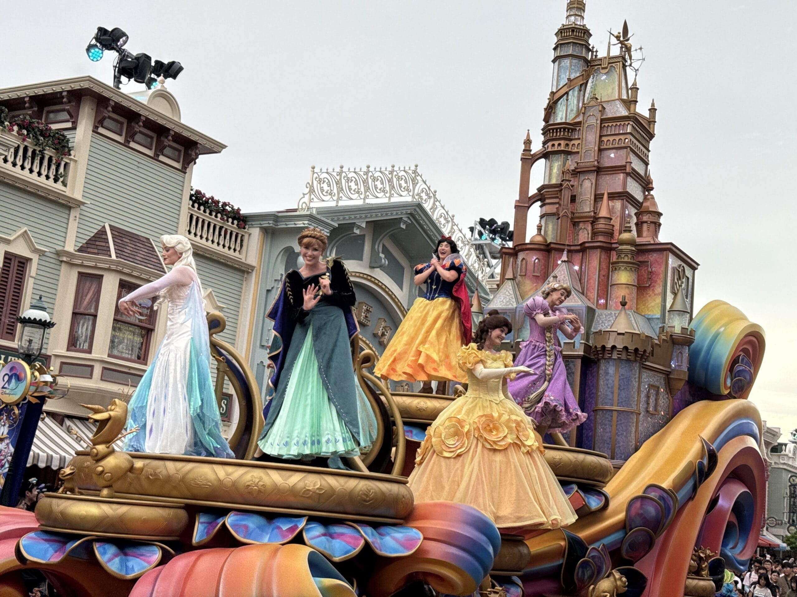 Five costumed princess performers wave atop a colorful float during the Friendtastic Parade at Hong Kong Disneyland.