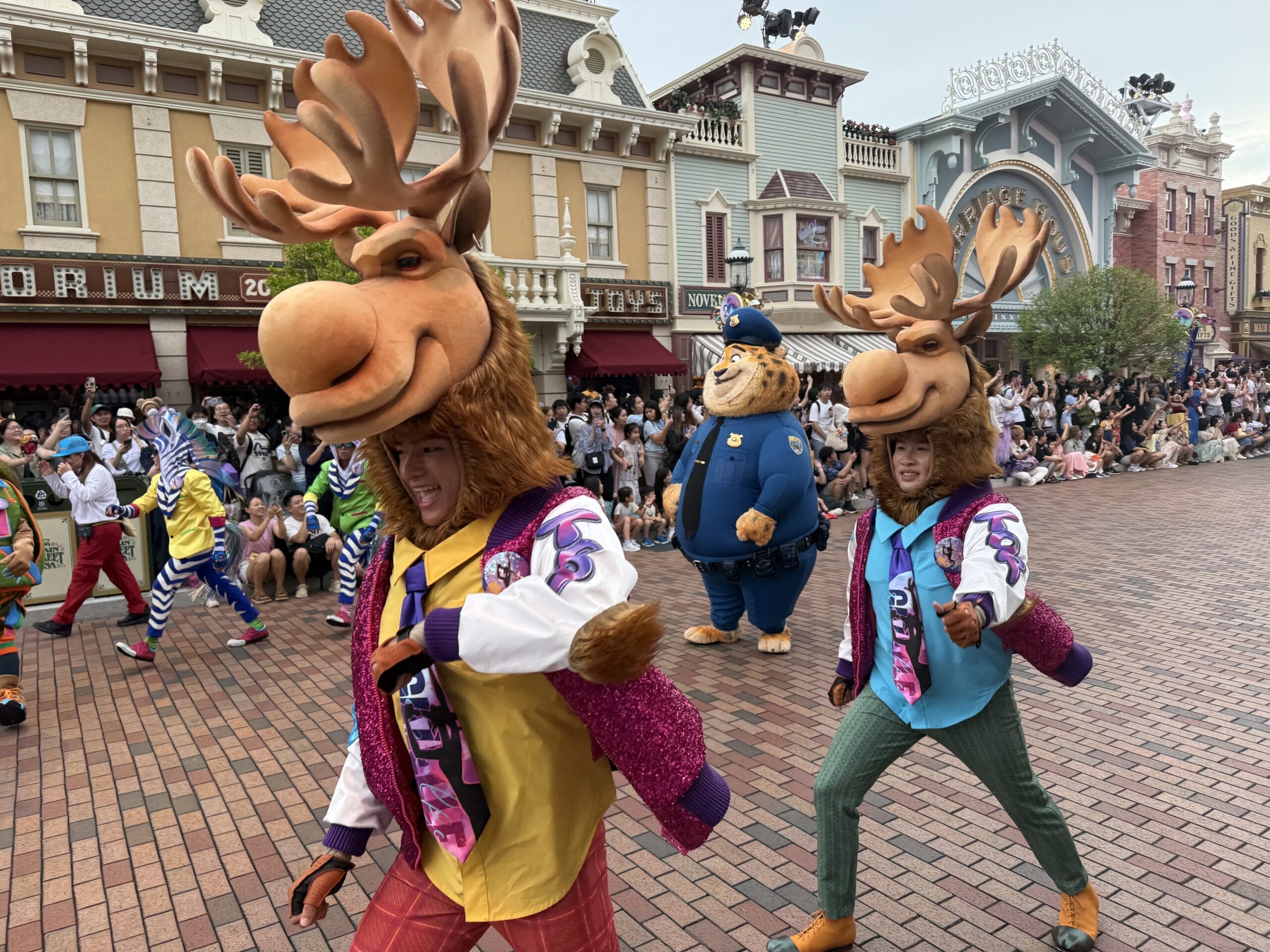 Two moose and a police bear costume join the Friendtastic Parade at Hong Kong Disneyland, delighting theme park crowds.