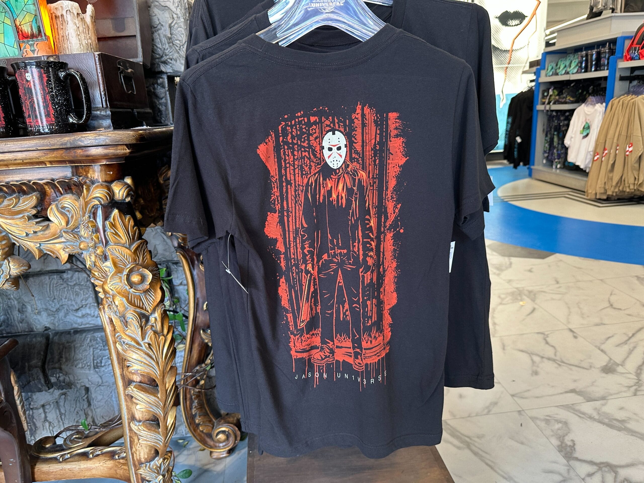 Black T-shirt featuring a masked figure in a red forest, part of exclusive JASON UN1V3RSE merchandise.