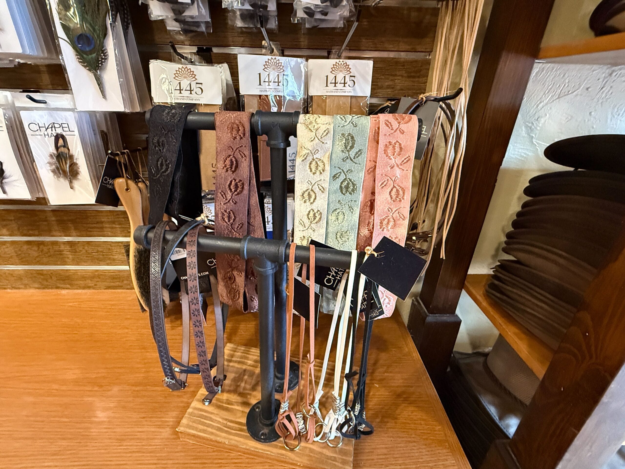 Decorative fabric headbands hang on a display rack at the Prairie Outpost in Magic Kingdom, with accessories nearby.