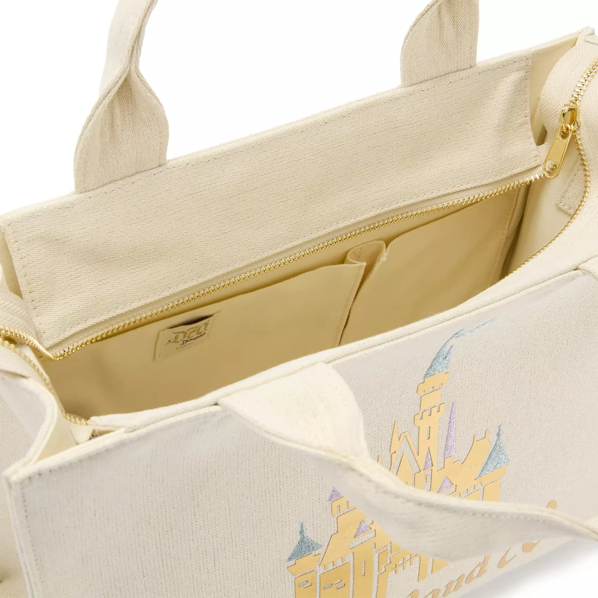 Cream-colored tote bag with a zippered inner pocket and pastel castle design on the outside.