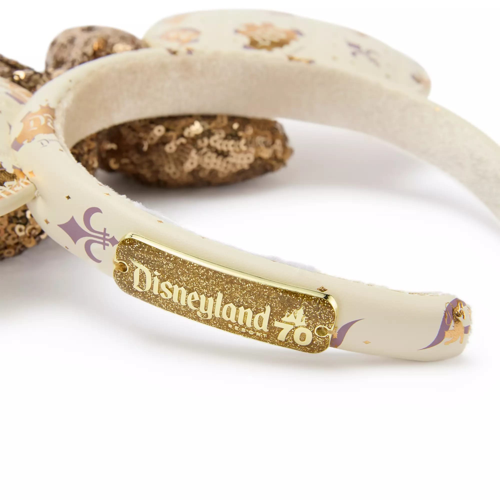 Close-up of a headband with a gold tag reading "Disneyland 70" and sequined Mickey Mouse ears.