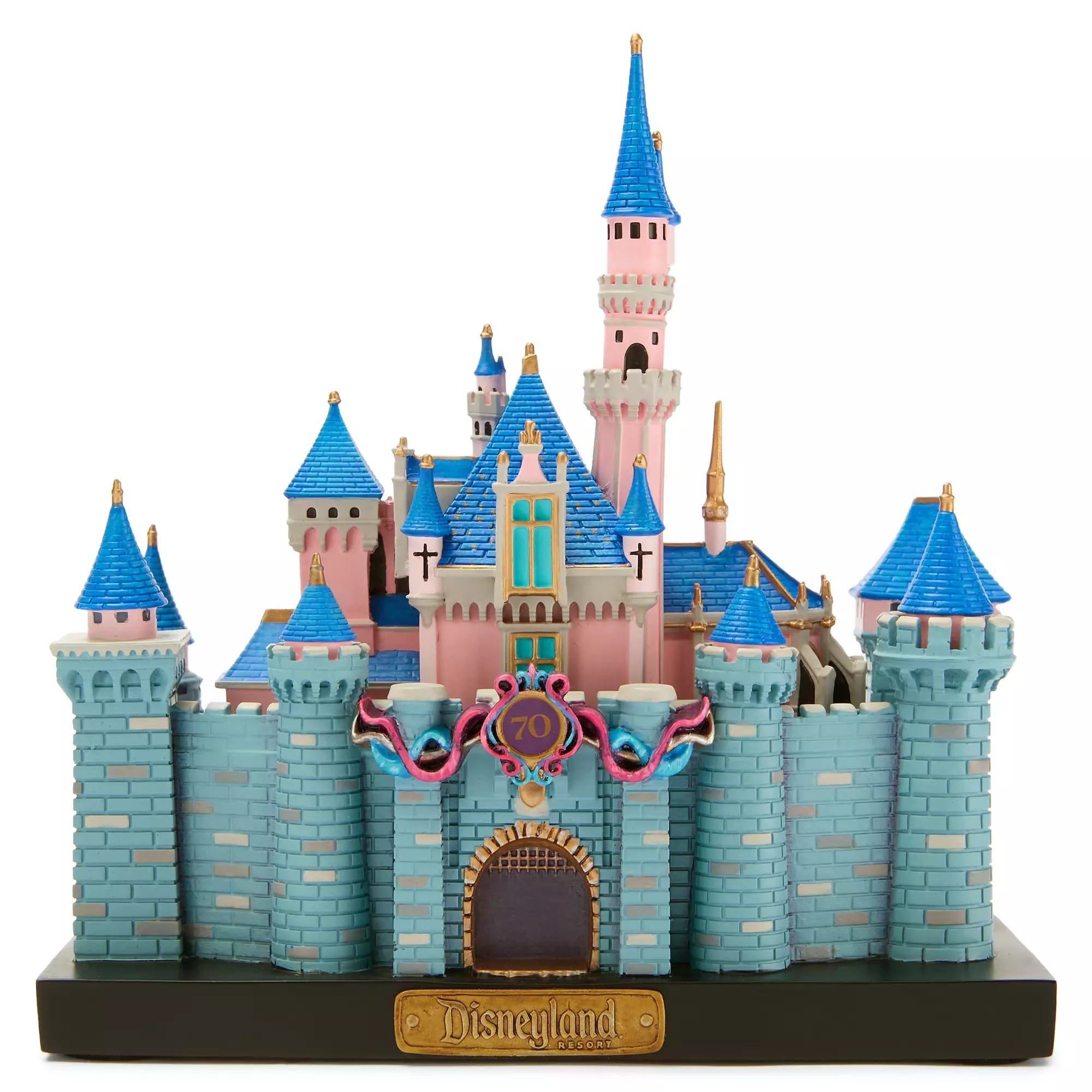 A model of Disneyland’s Sleeping Beauty Castle with blue roofs, pink walls, and a "70" anniversary banner above the gate.