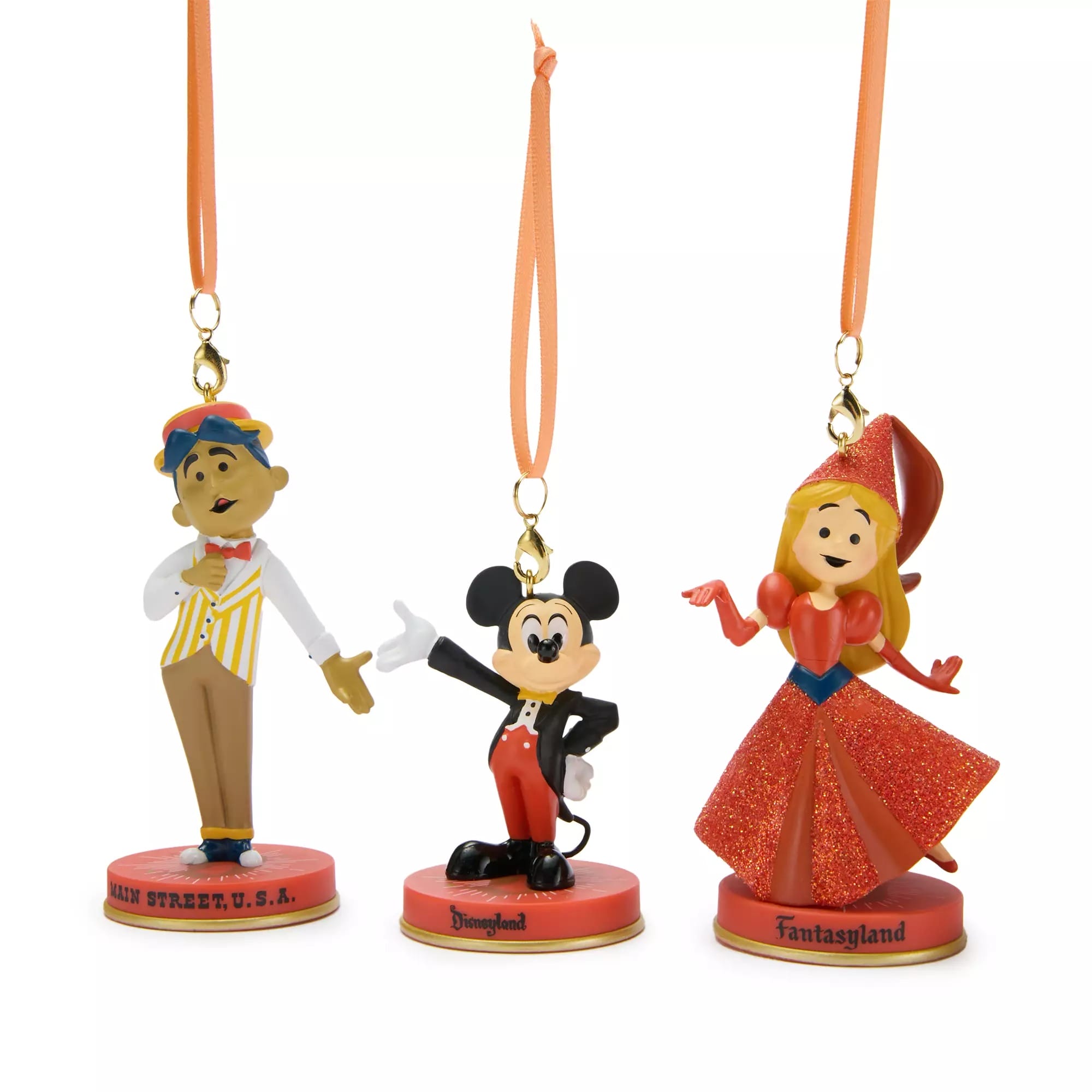 Three Disney character ornaments—Mickey Mouse, Aurora, and a Main Street cast member—hang by orange ribbons.