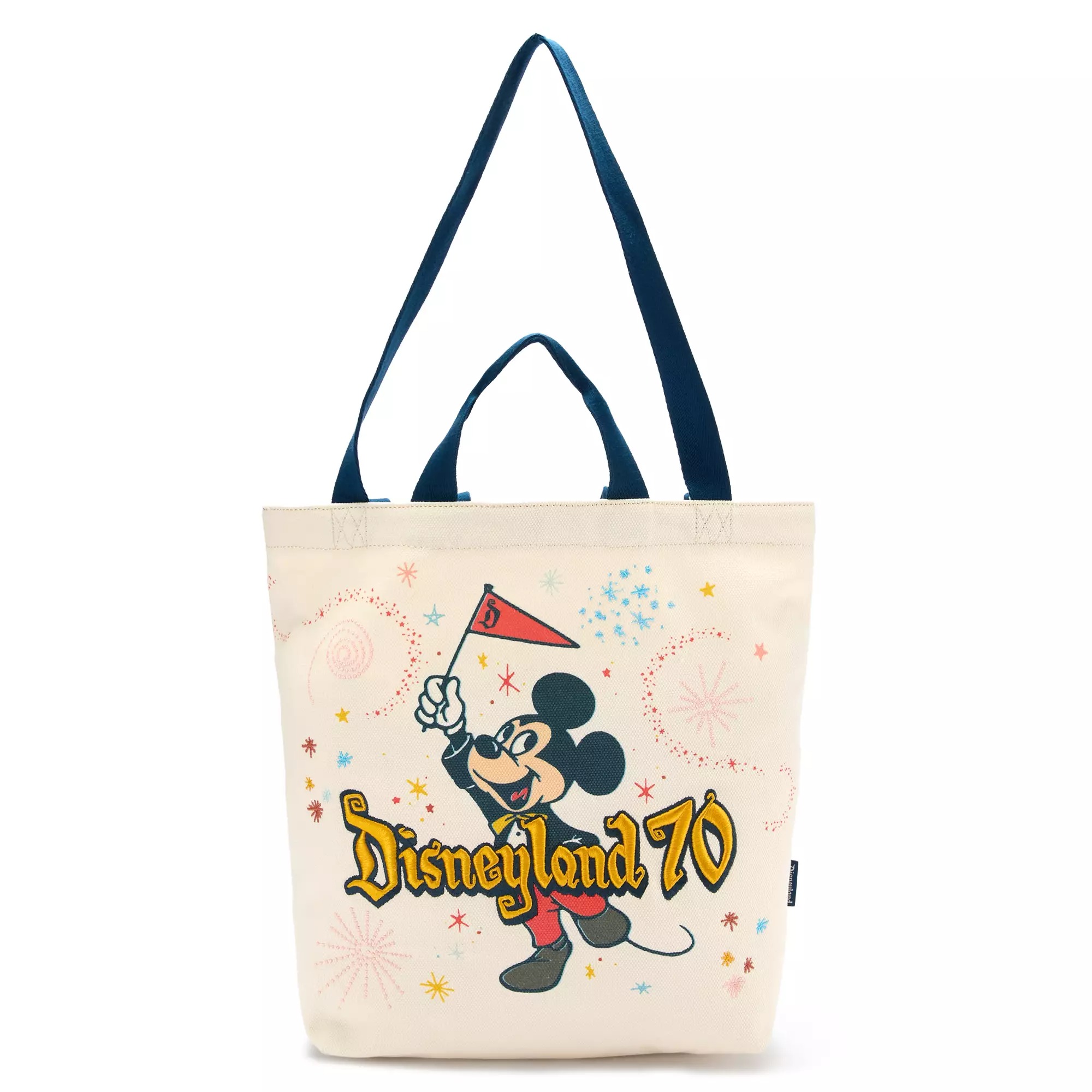 Beige tote bag with Mickey Mouse, fireworks, and "Disneyland 70" printed on the front.