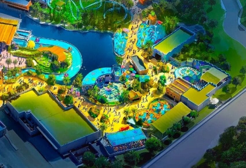 Aerial view of the colorful, illuminated Universal Kids Resort, nestled among dense green trees and winding roads.