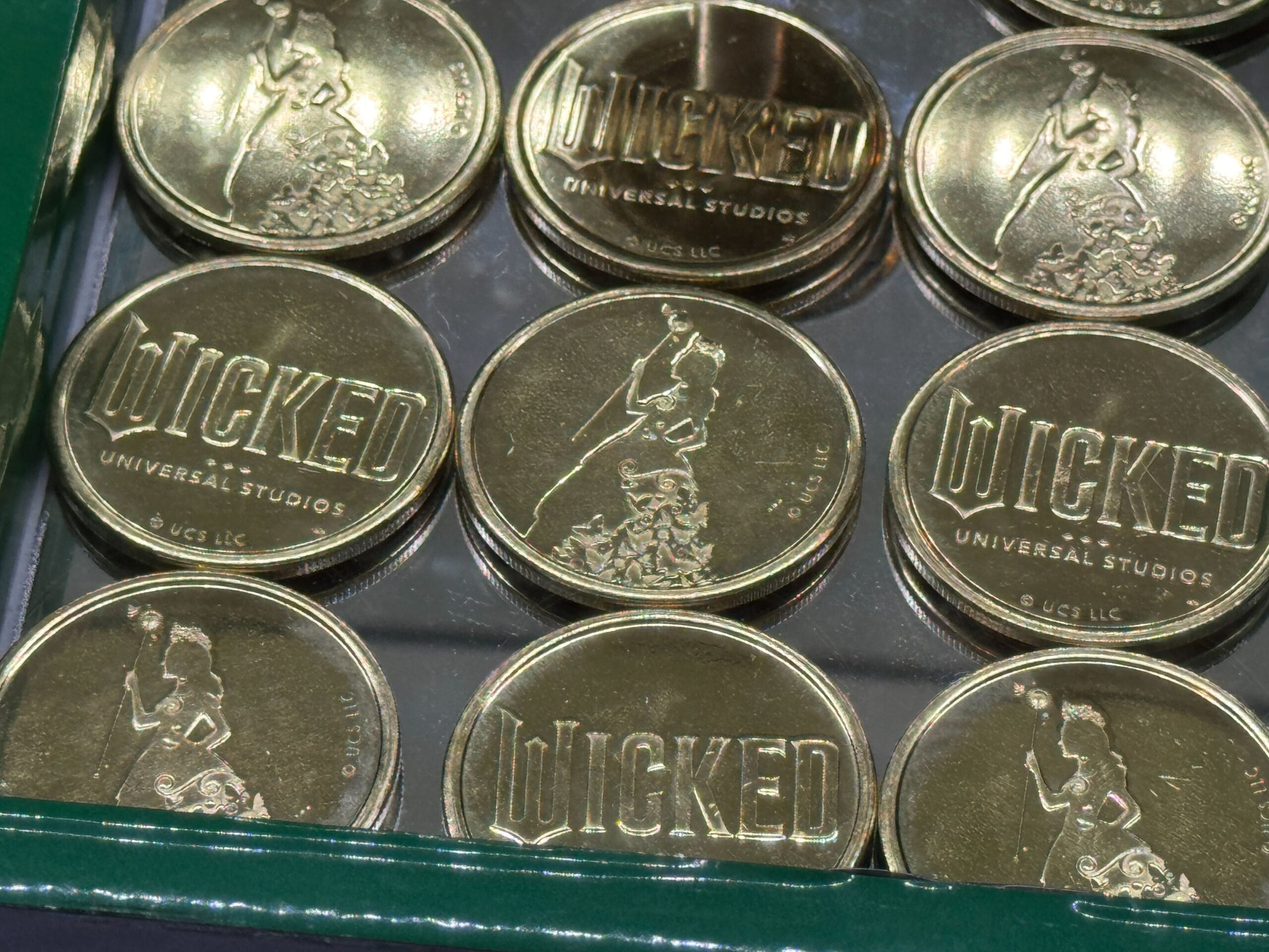 Gold Collectible Medallions from Universal Studios Florida, each embossed with "WICKED" and a woman's silhouette.