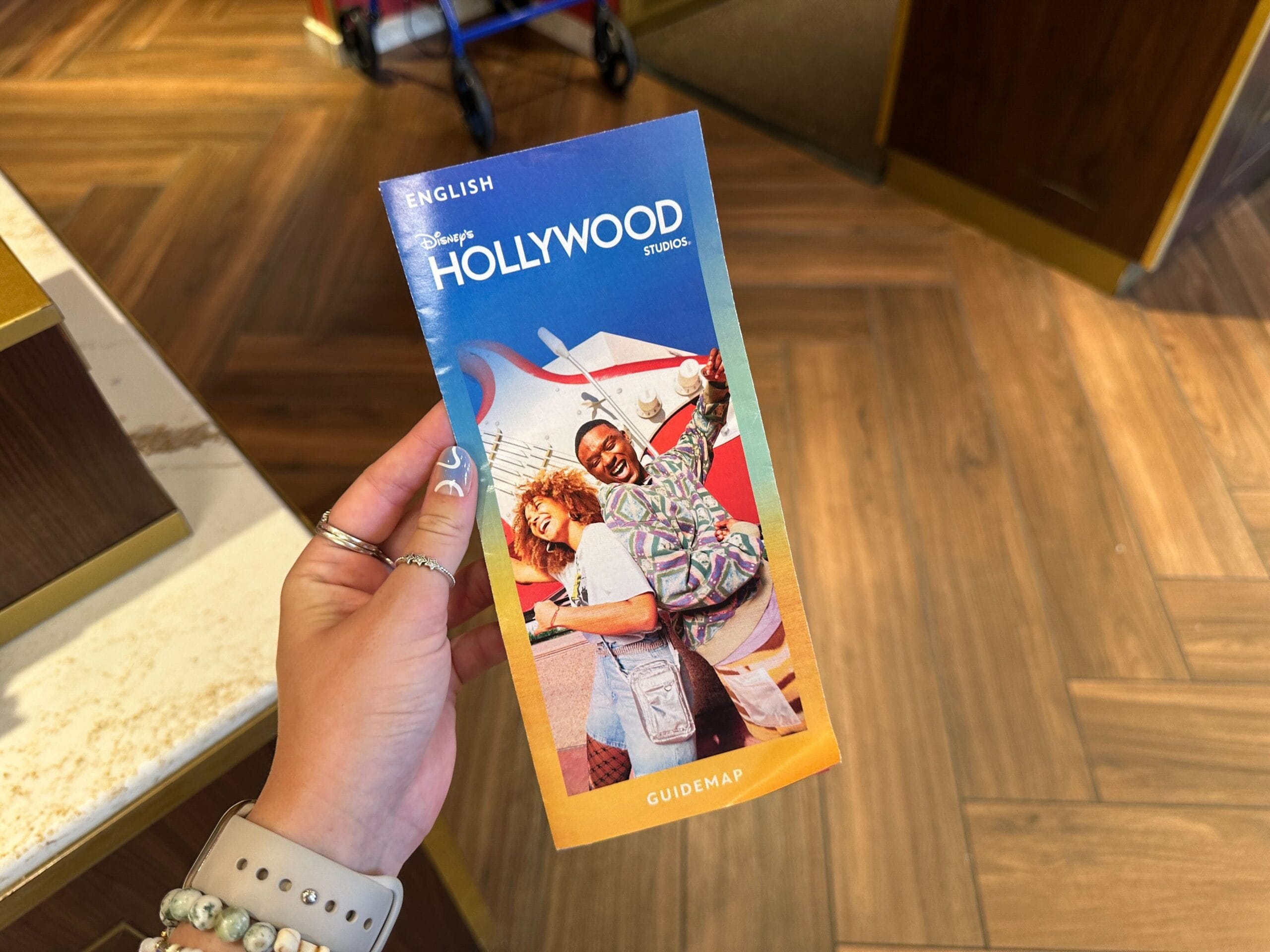 Hand holding a Disney’s Hollywood Studios guidemap featuring a smiling couple and MuppetVision 3D on the cover.