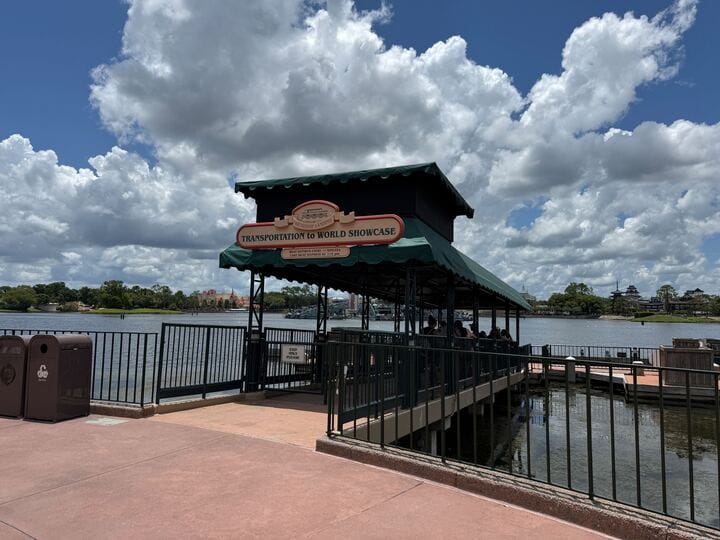 Friendship Boat Transportation dock to EPCOT World Showcase near Canada and Germany sits beside a lake under a partly cloudy sky.